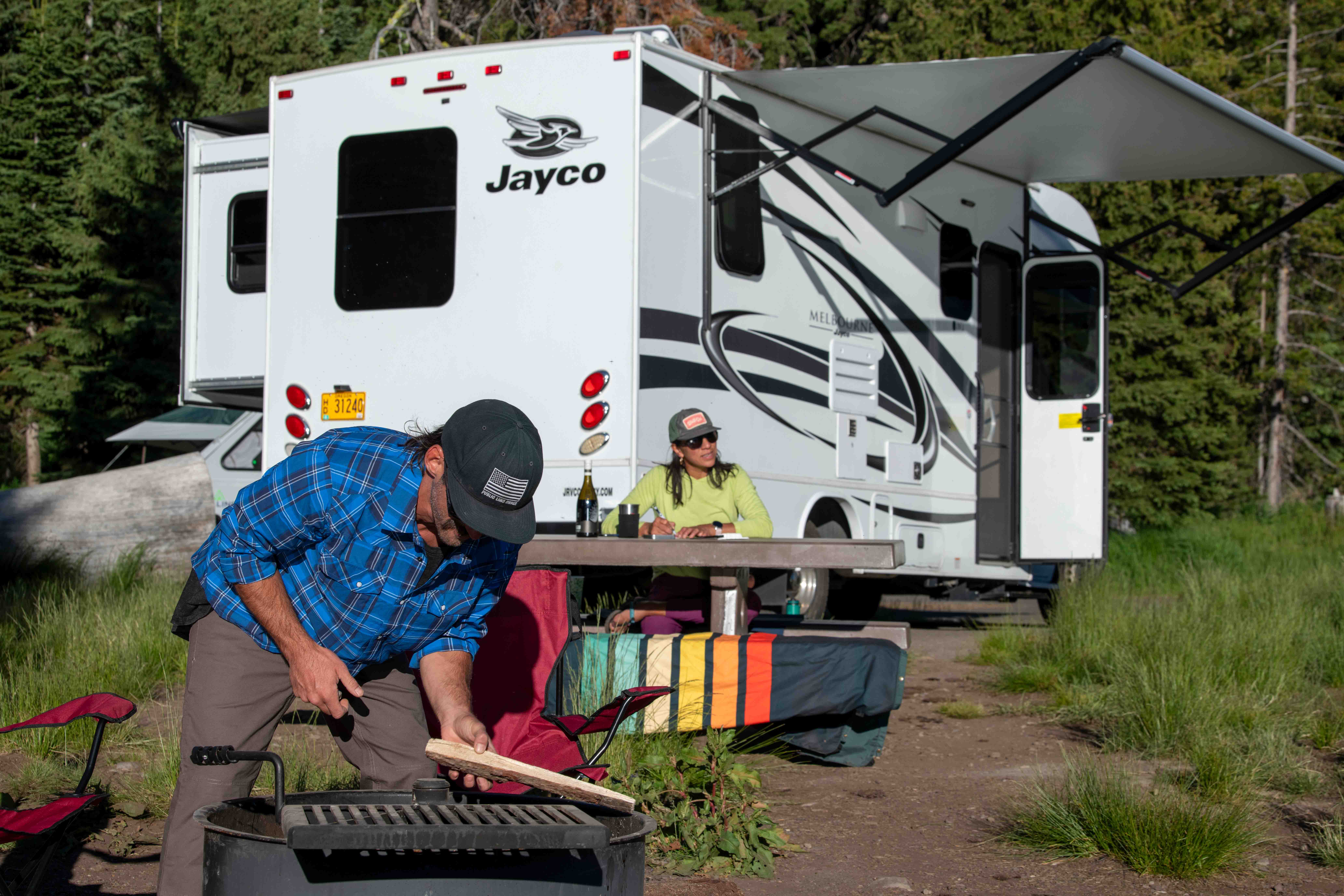 Dani Reyes-Acosta and her partner Johnny doing activities next to a Jayco Melbourne Class C motorhome.