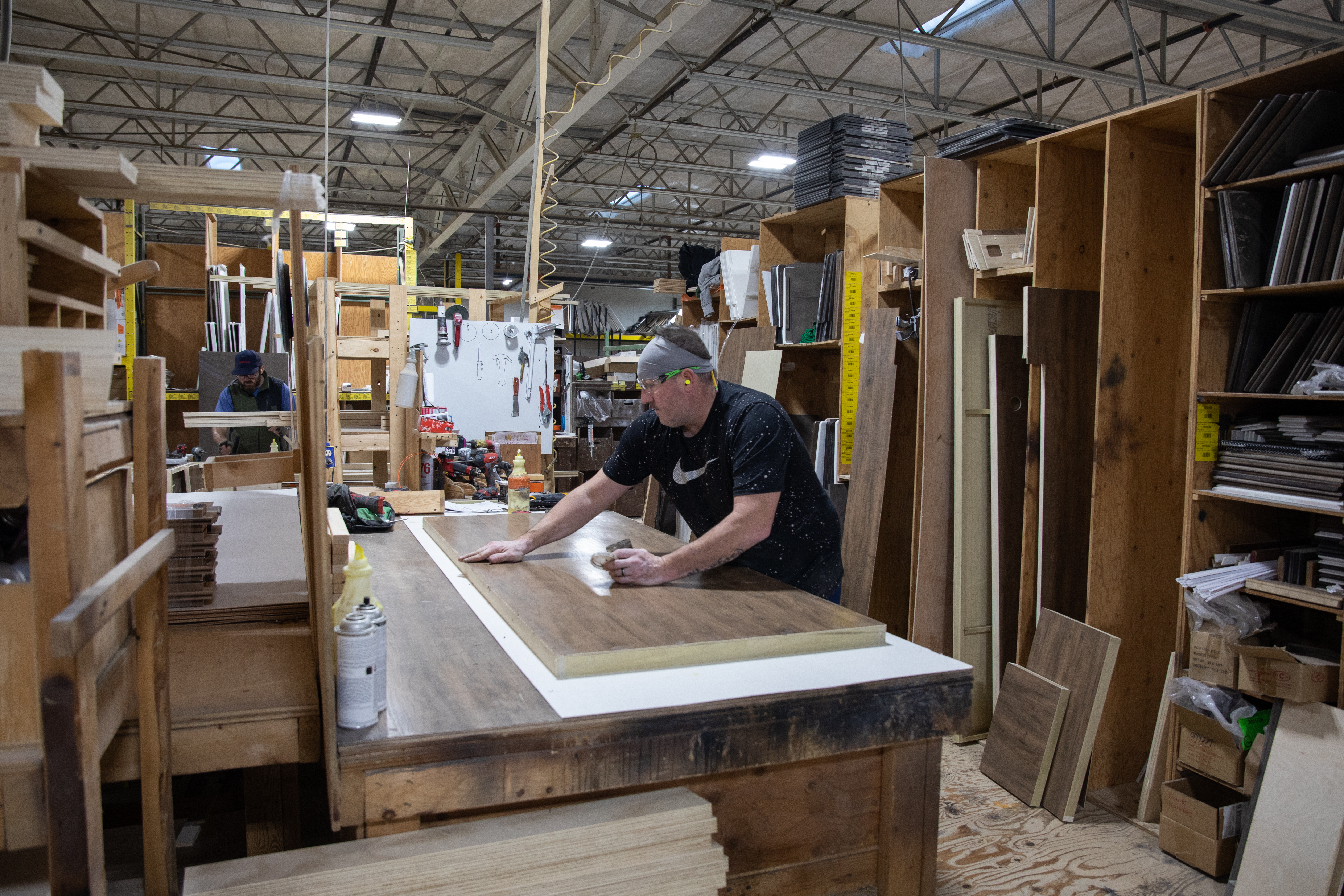 A THOR Industries team member works with a piece of wood in a manufacturing center.