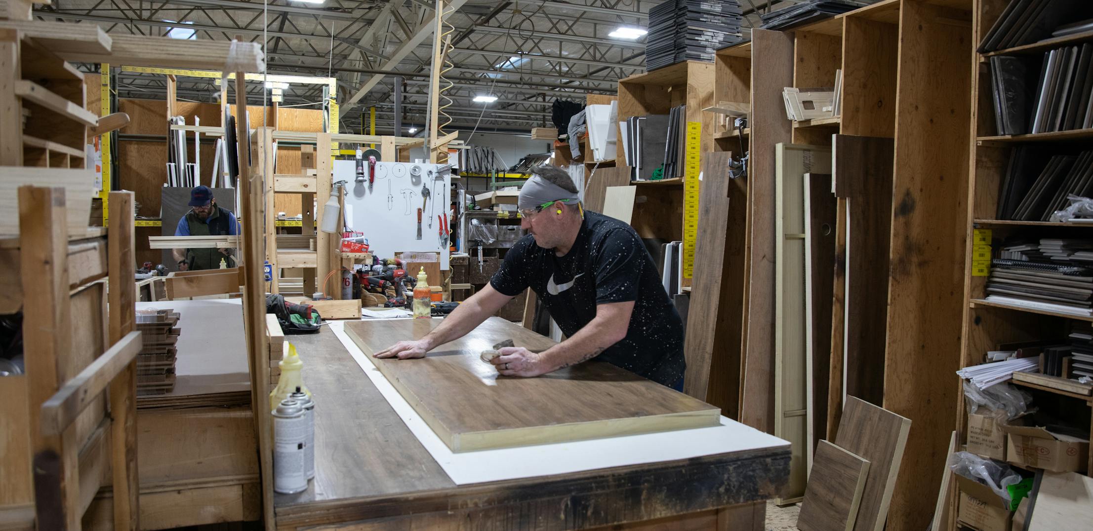 A THOR Industries team member works with a piece of wood in a manufacturing center.