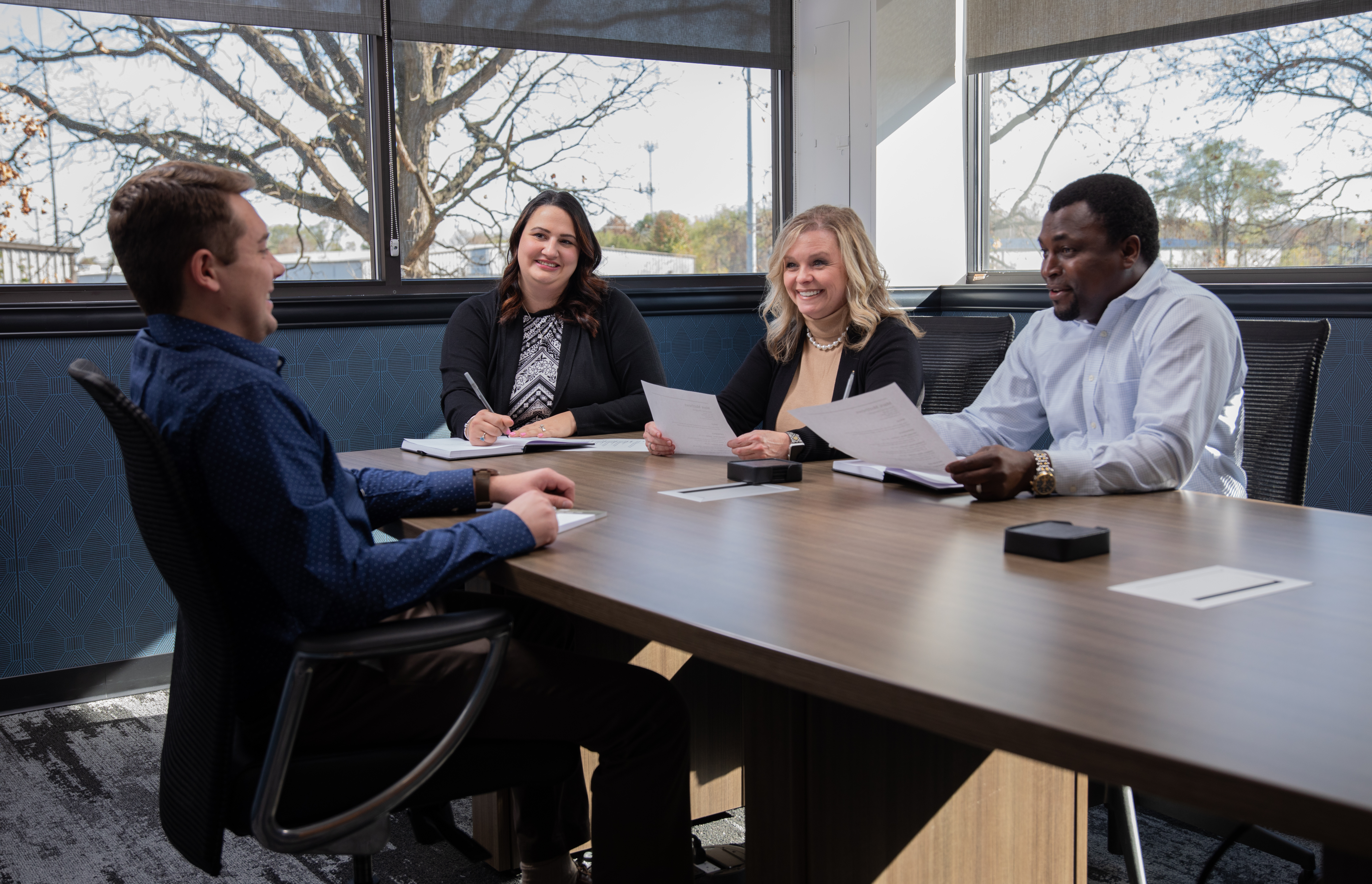 THOR Industries team members sit at a table during a business meeting.