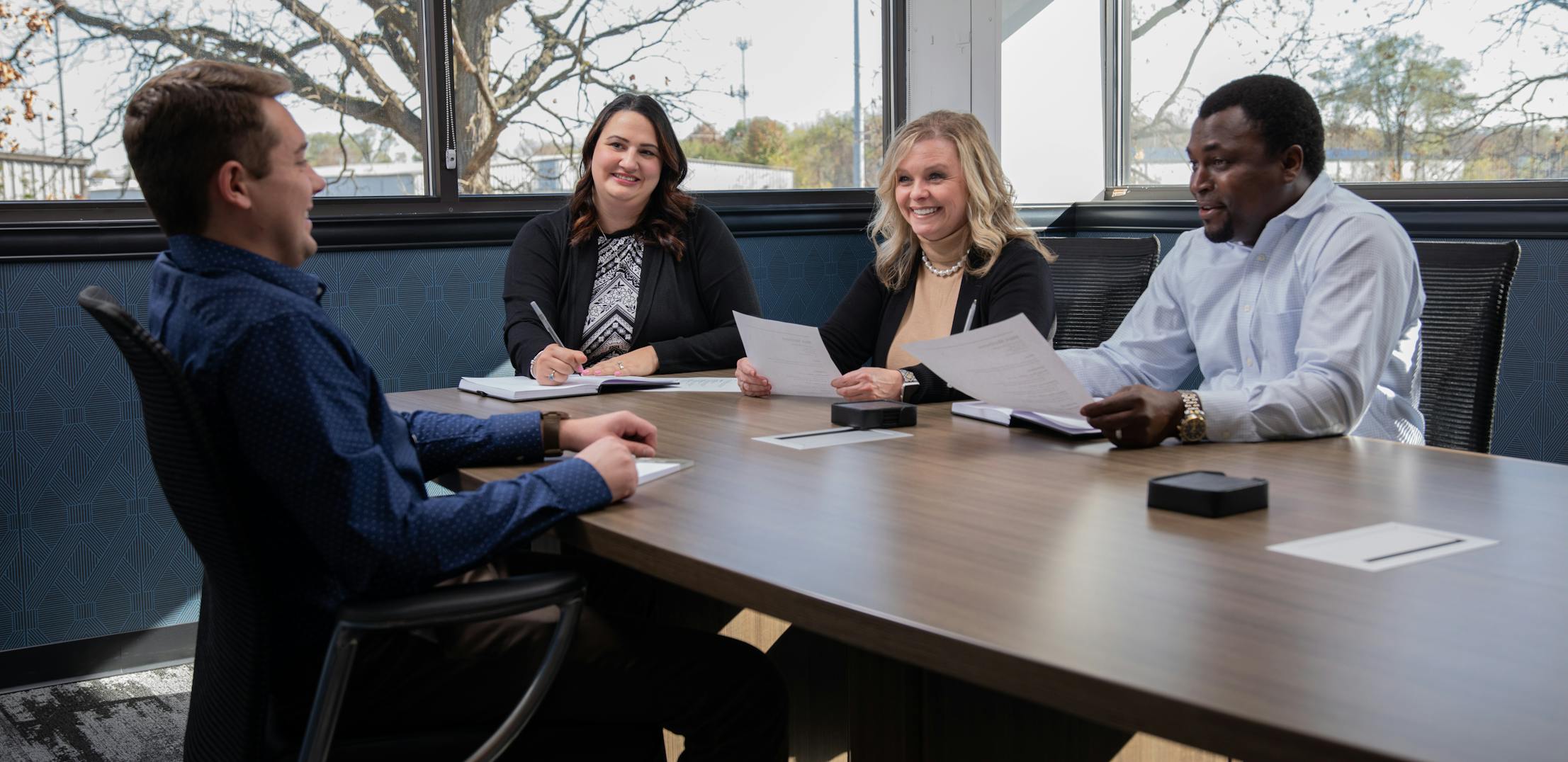 THOR Industries team members sit at a table during a business meeting.