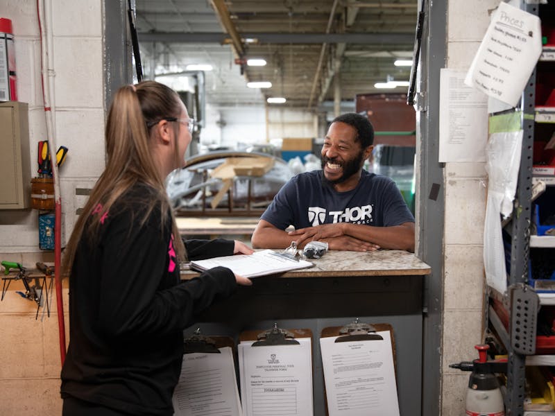 A man and a woman converse in a warehouse.