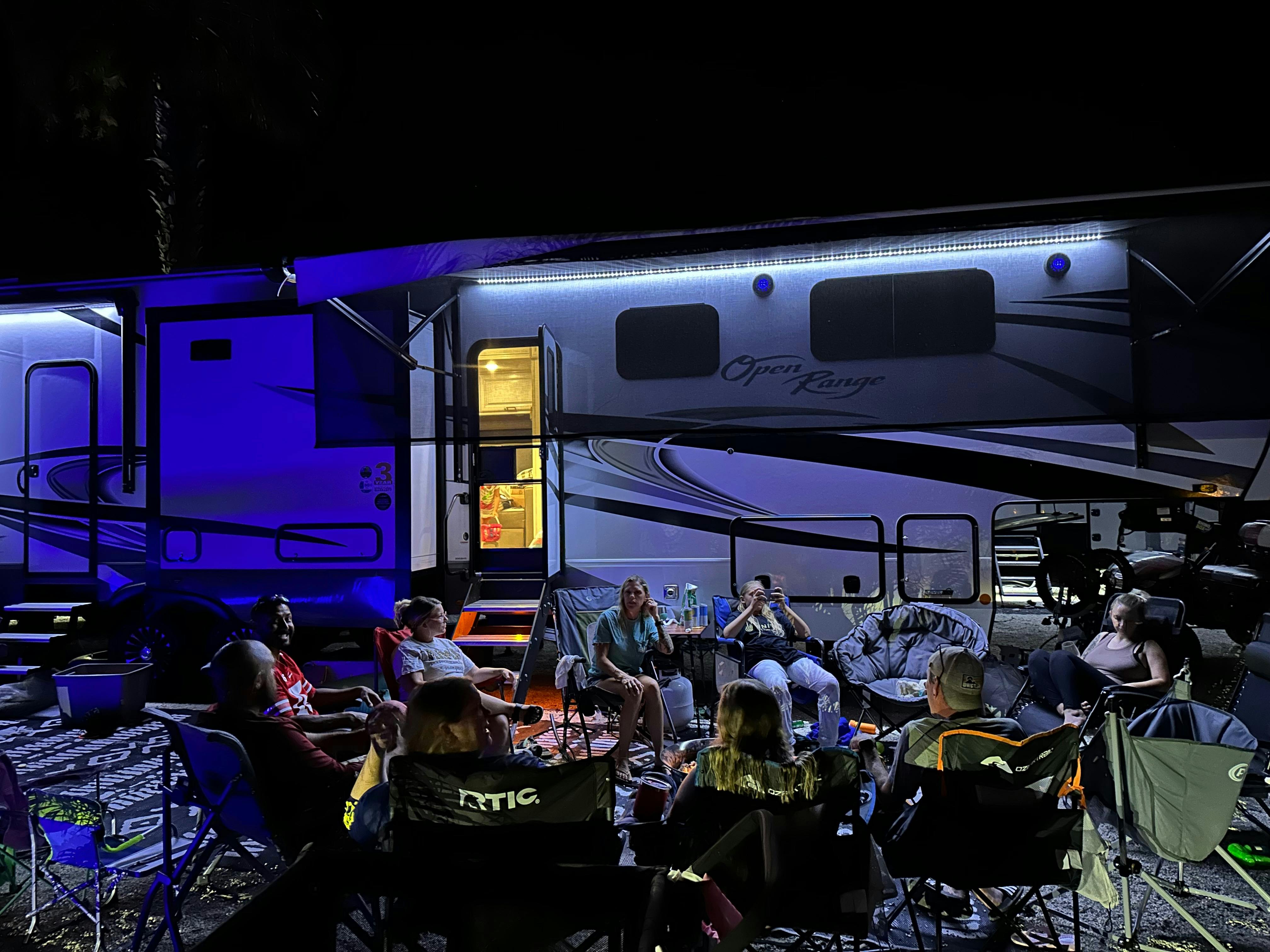 The Cassie and Joshua Bailey family host guests around a campfire outside of their Highland Ridge Open Range.