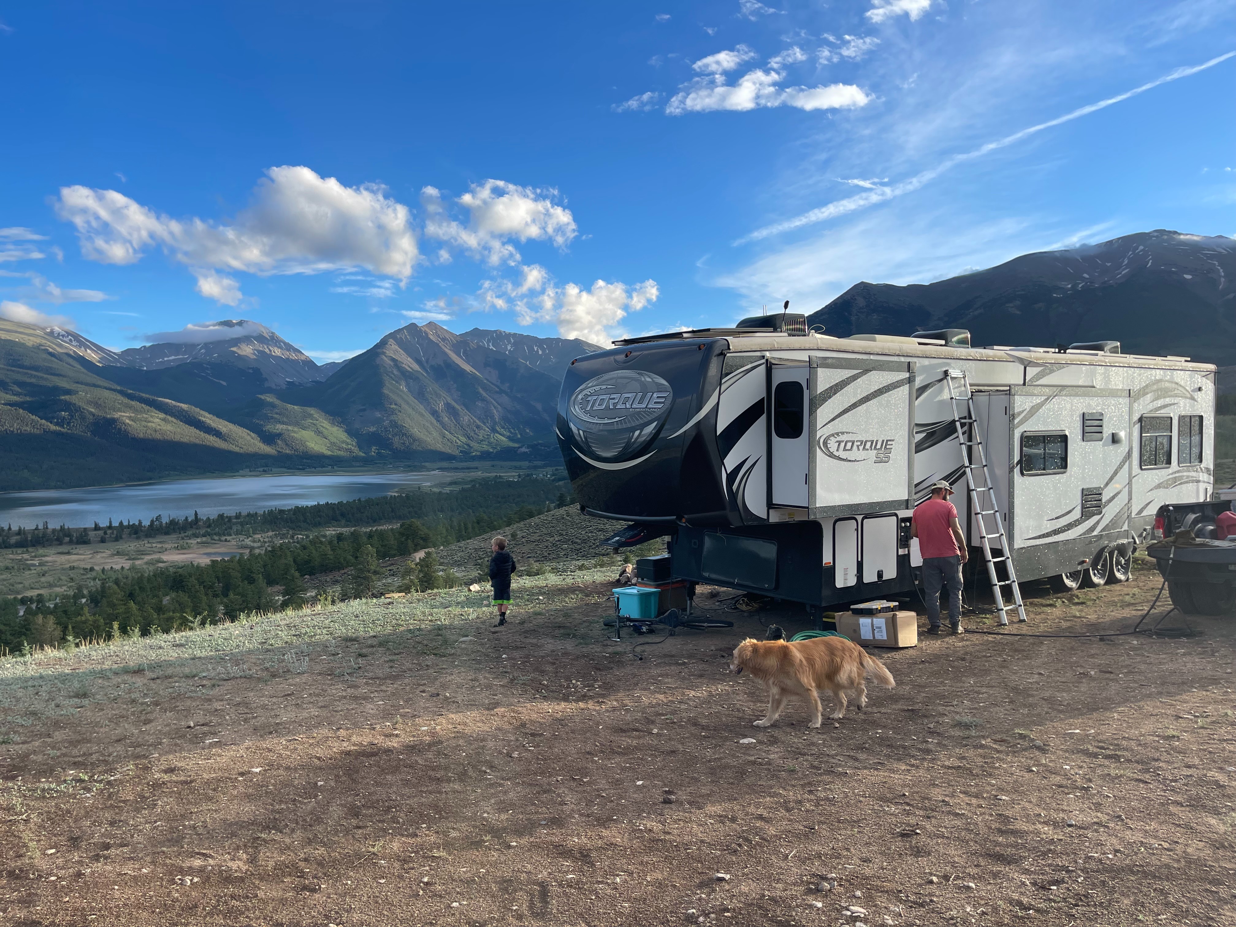 Melissa and Lucas Lahr's Heartland Torque toy hauler at a campsite with panoramic mountain views.