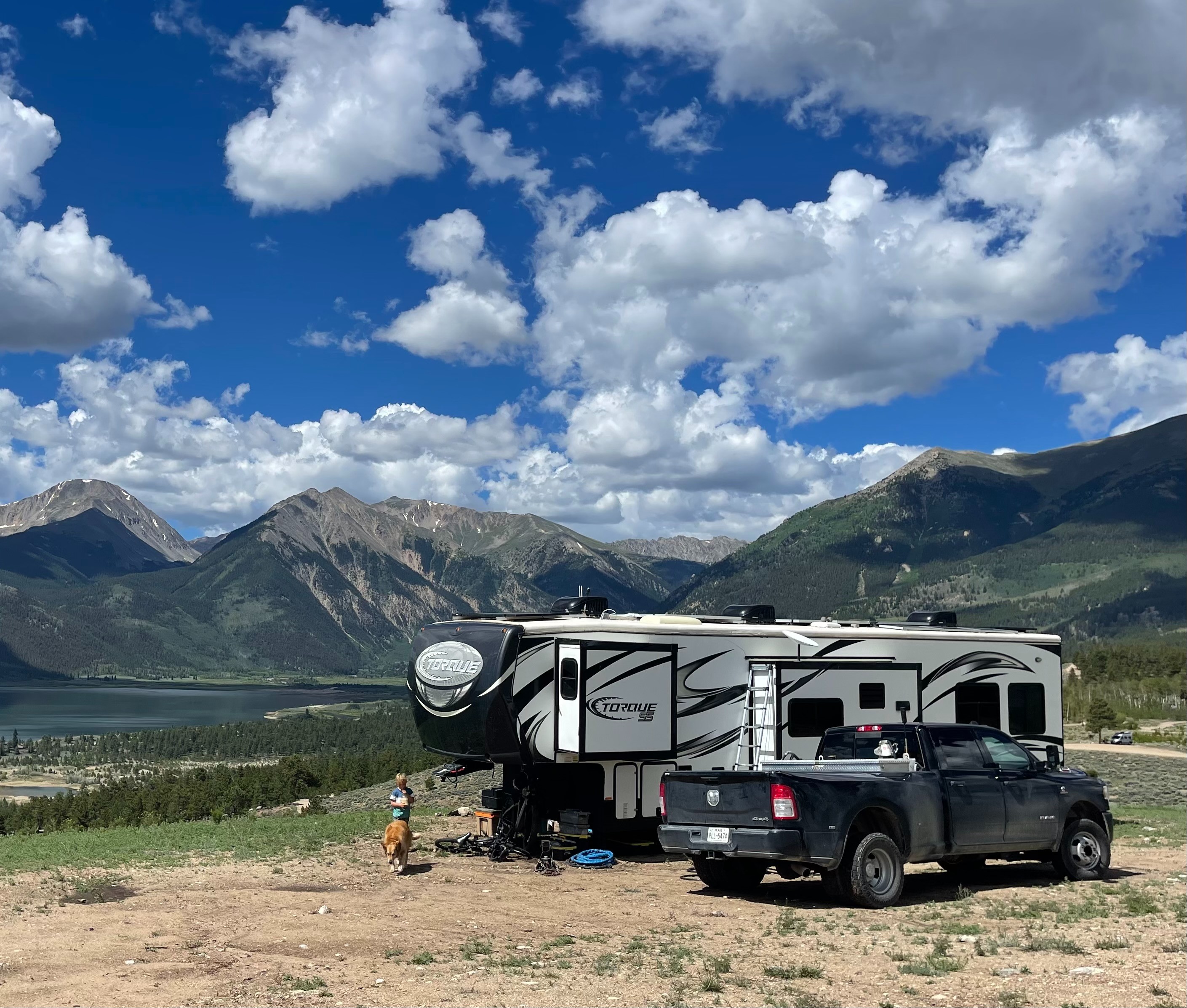 Melissa and Lucas Lahr's Heartland Torque toy hauler at a scenic lookout featuring mountains  and cloudy skies.