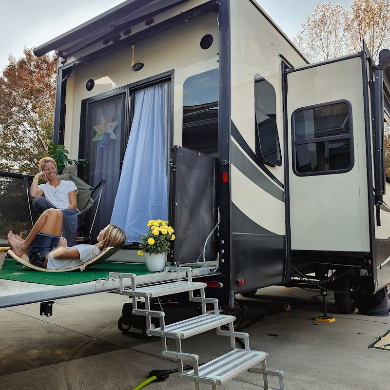 Bibi Barringer and her kids sit on the patio of their KZ Durango Gold fifth wheel.
