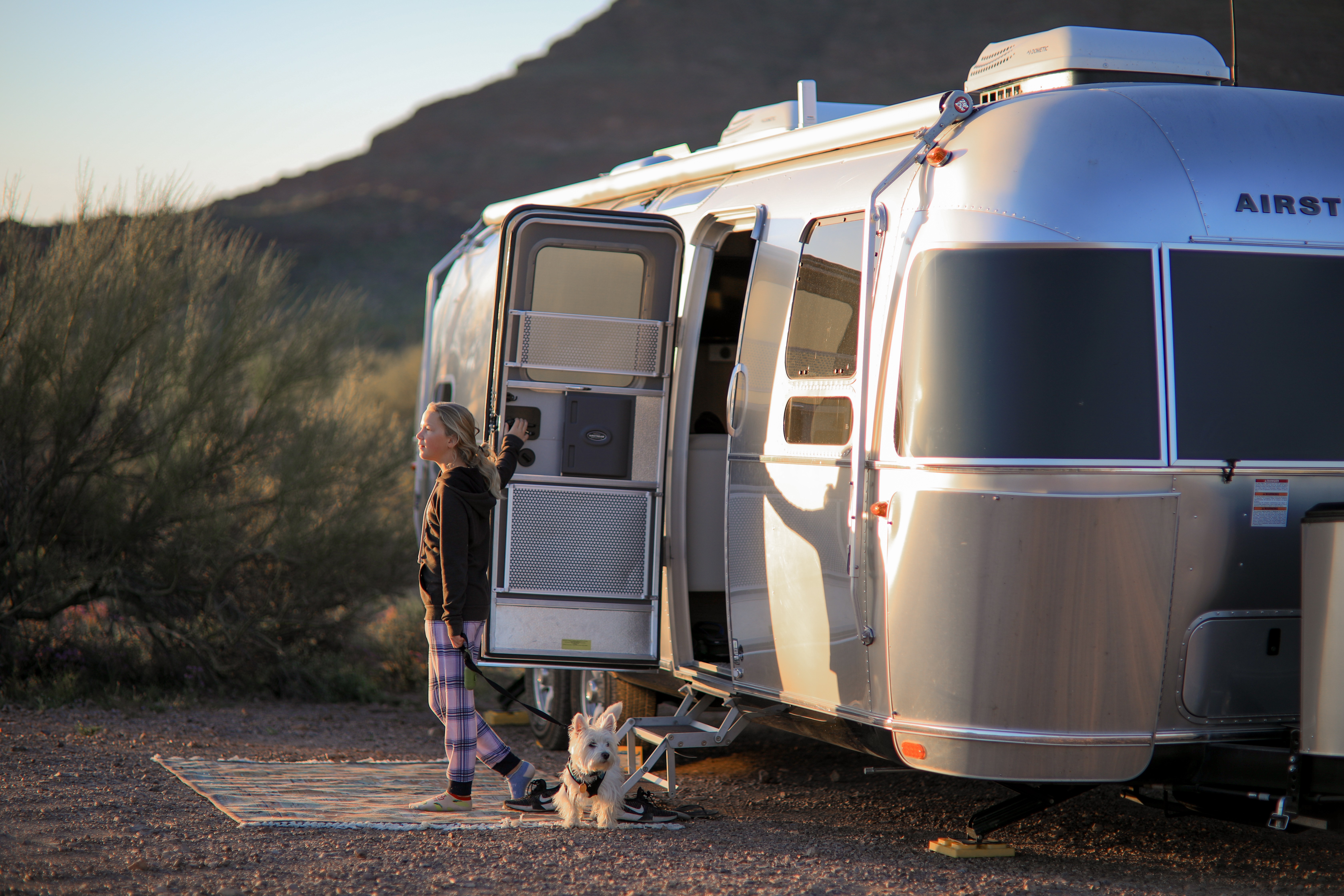 Lilya Blue steps out of an Airstream Flying Cloud.