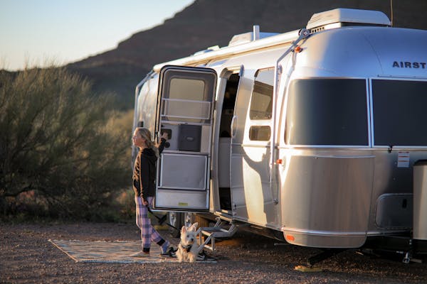 Lilya Blue steps out of an Airstream Flying Cloud.