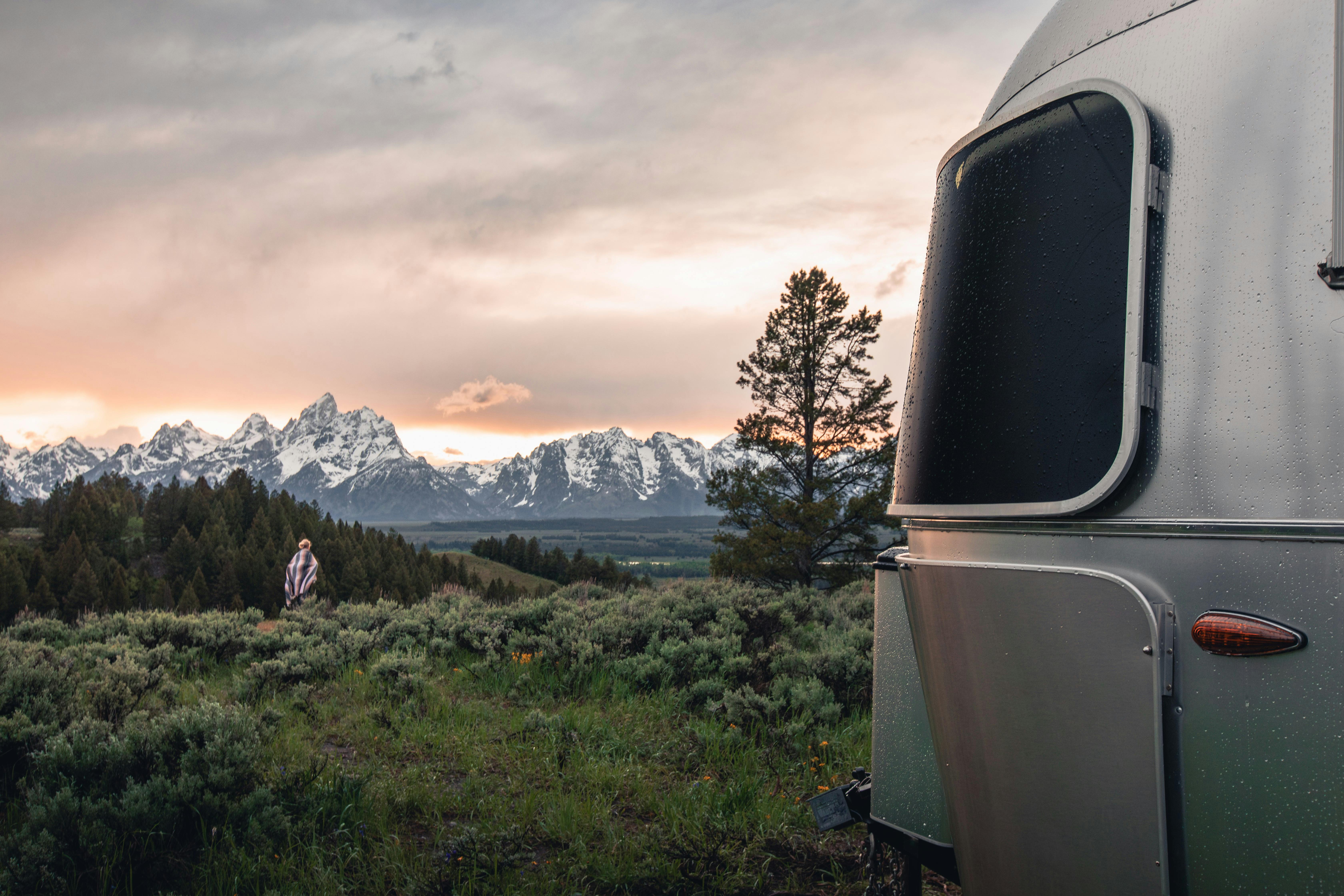 An Airstream Flying Cloud in a grassy plain at sunset.