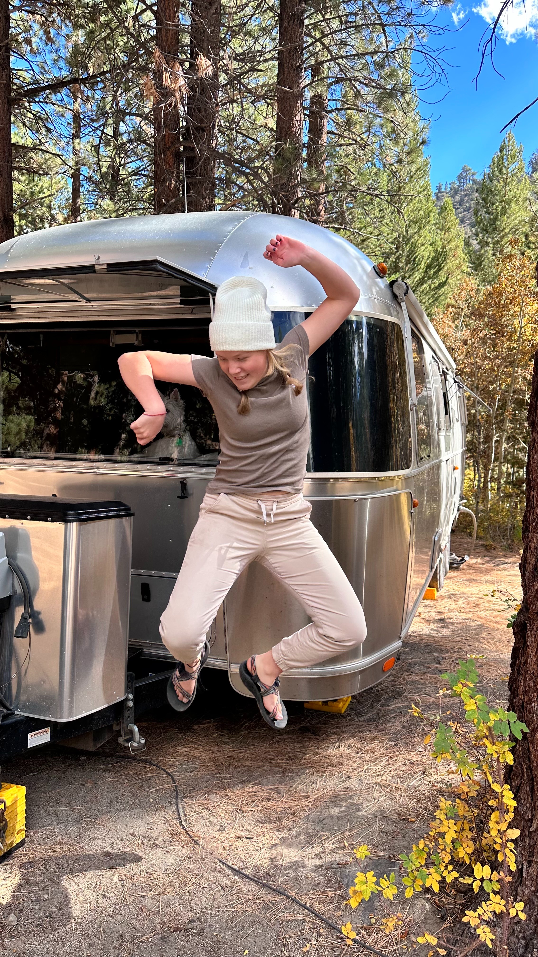 Lilya Blue jumps in front of her Airstream Flying Cloud.