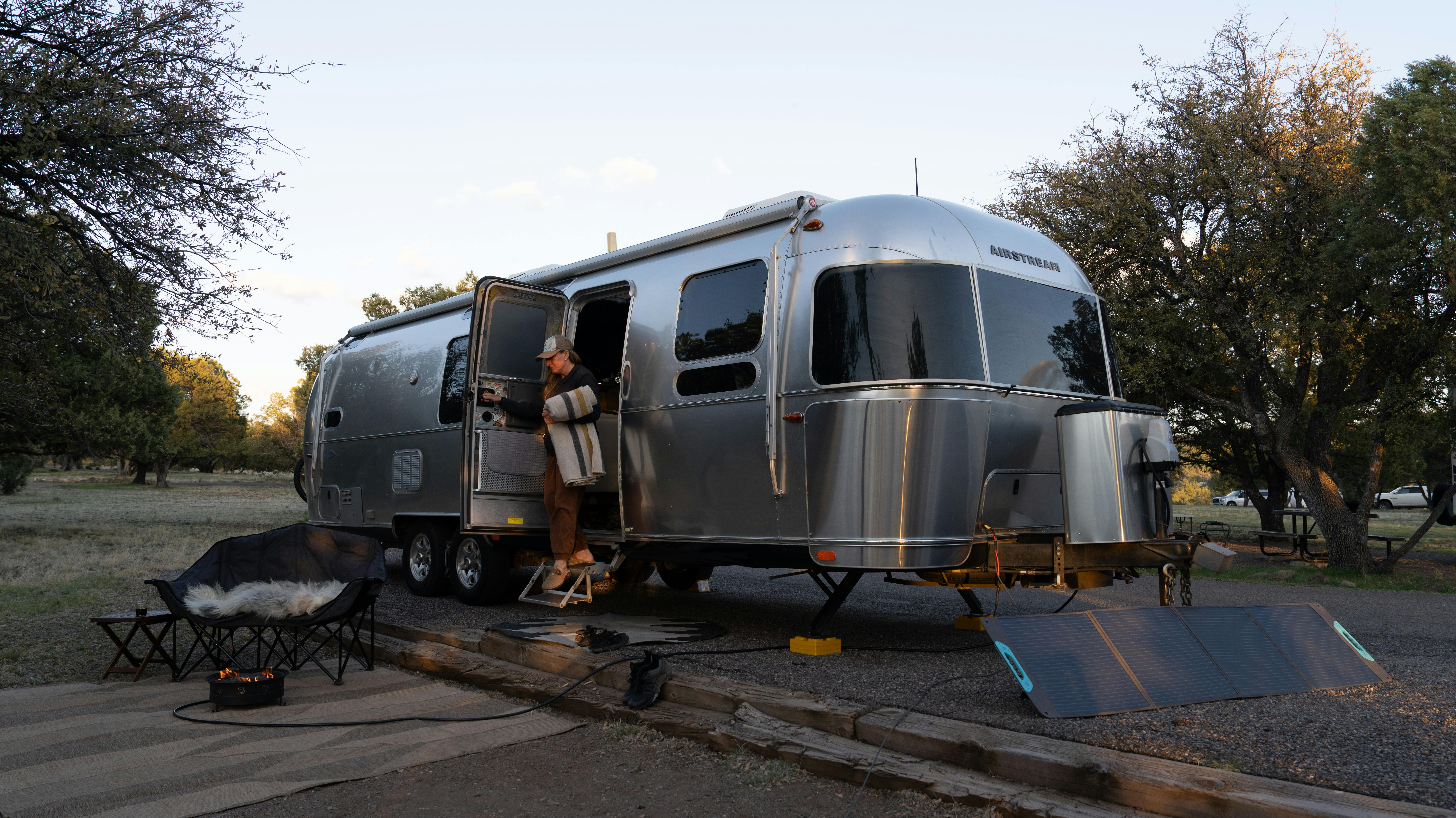 Karen Blue stepping out the door of her Airstream Flying Cloud travel trailer.