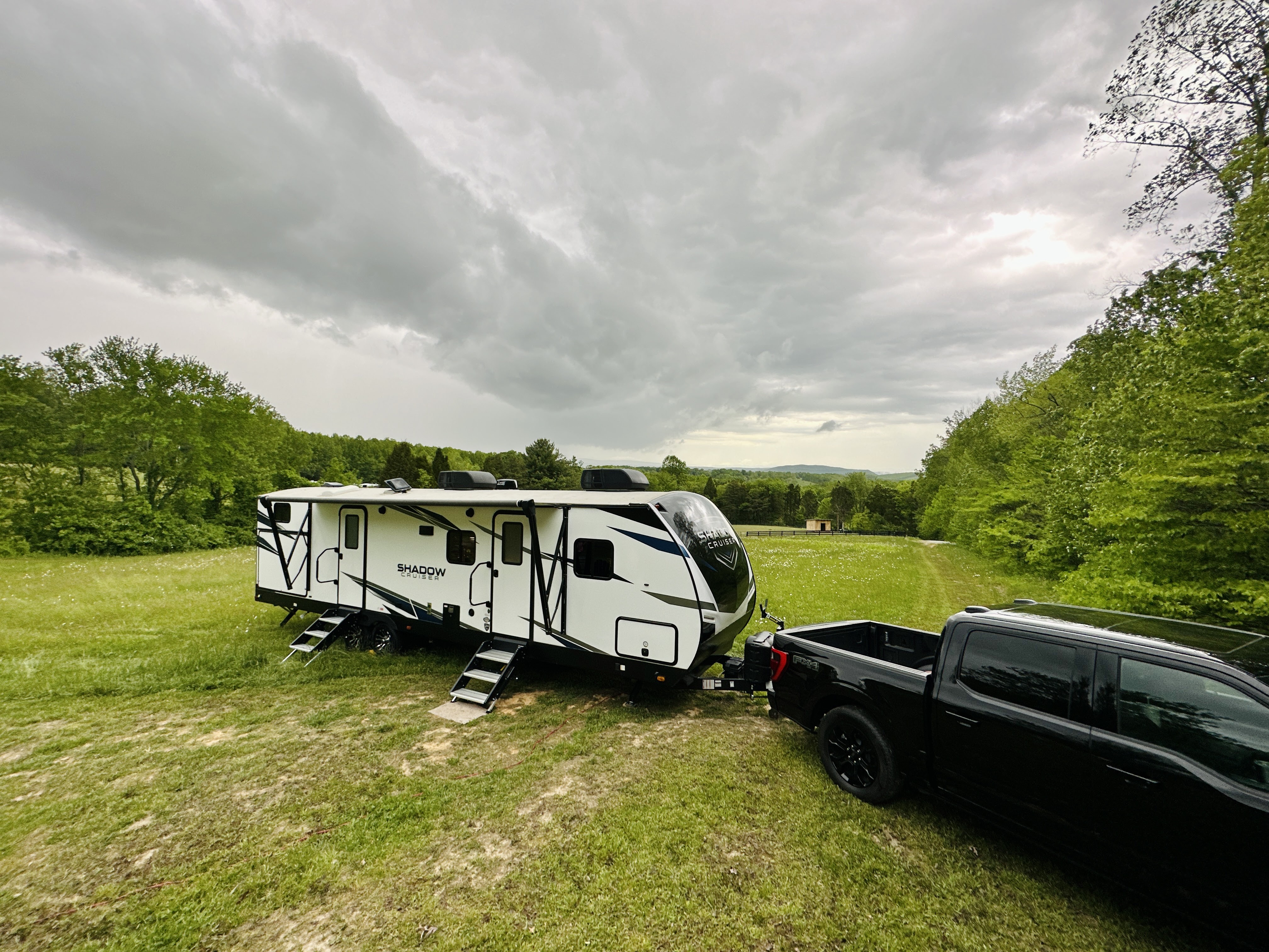 John King's Shadow Cruiser travel trailer parked in a grassy field.