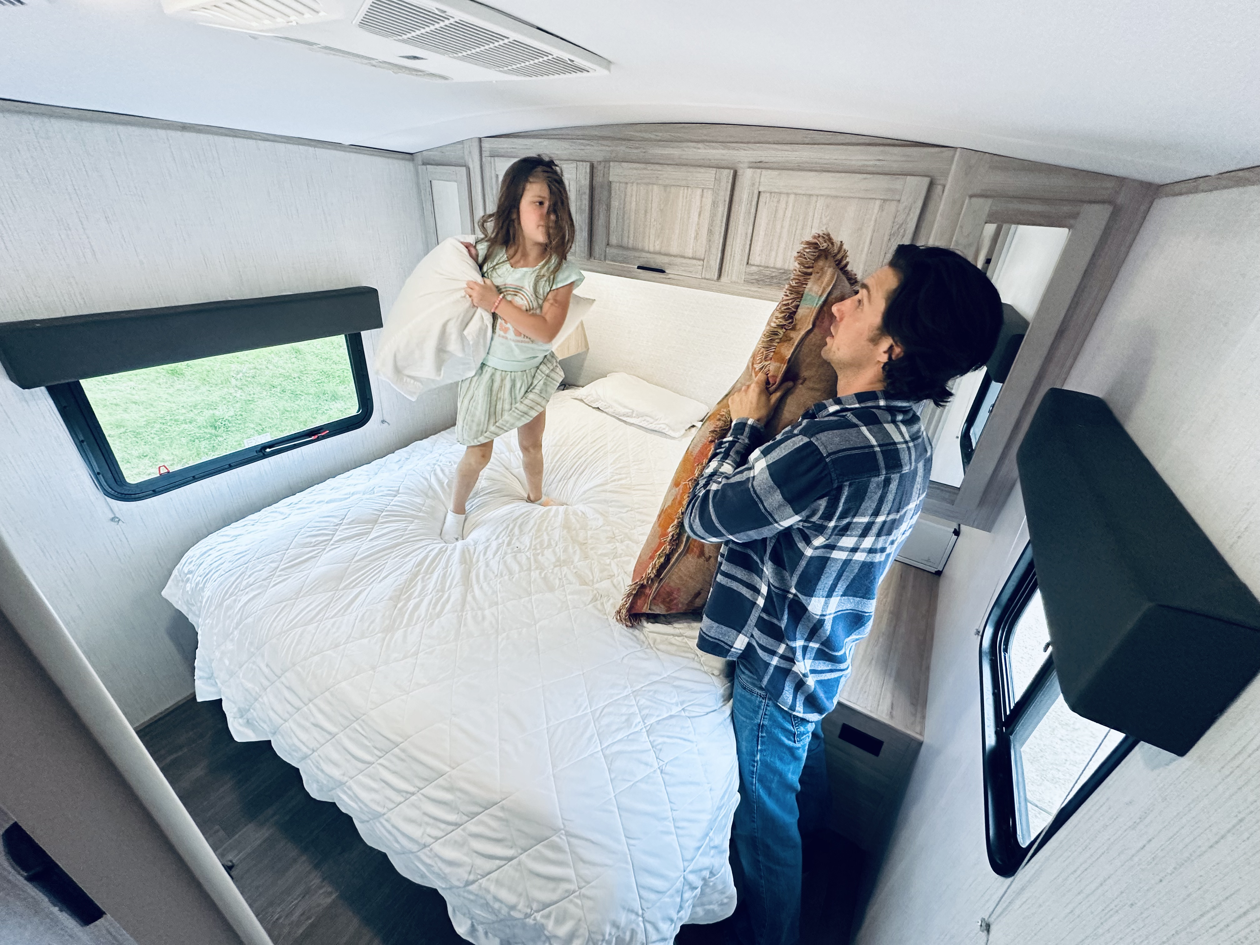 John King plays with his daughter inside their Shadow Cruiser travel trailer.