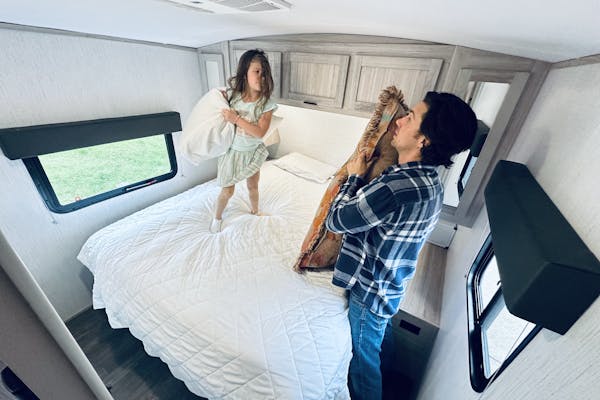 John King plays with his daughter inside their Shadow Cruiser travel trailer.