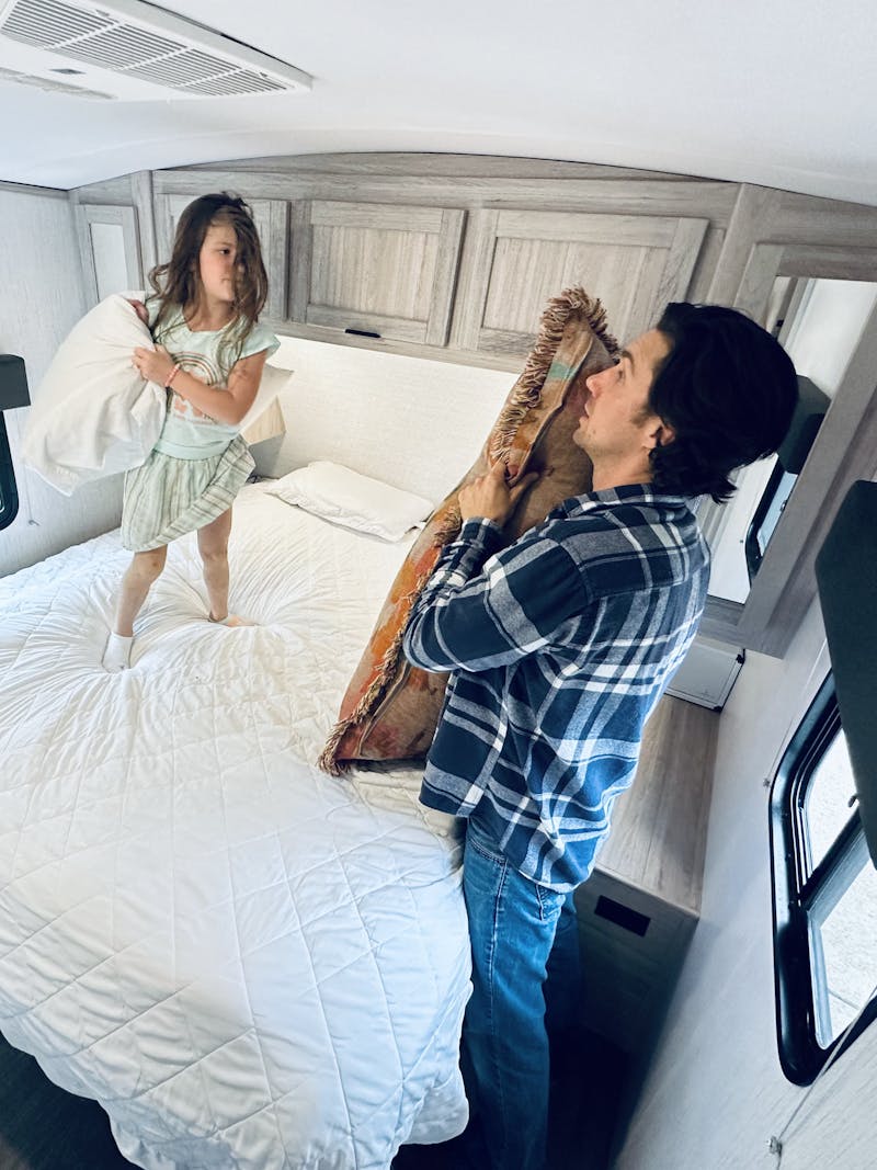 John King plays with his daughter inside their Shadow Cruiser travel trailer.