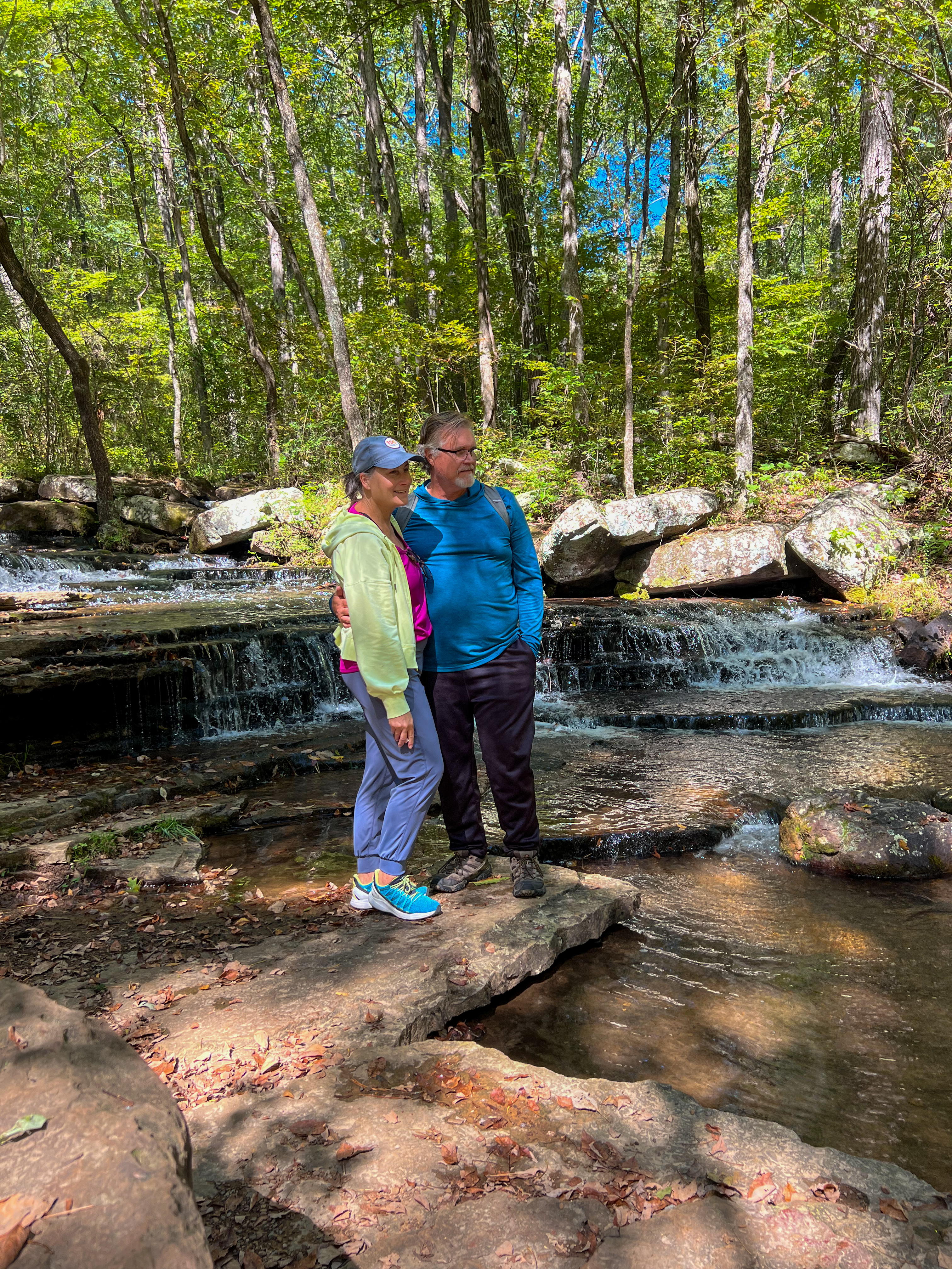 Donny and Tammy Benedict hiking near a stream.