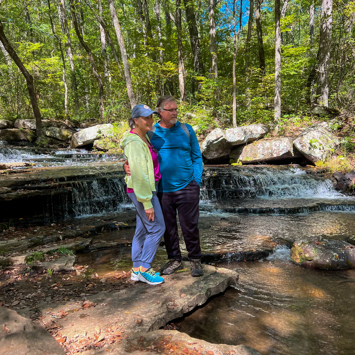Donny and Tammy Benedict hiking near a stream.