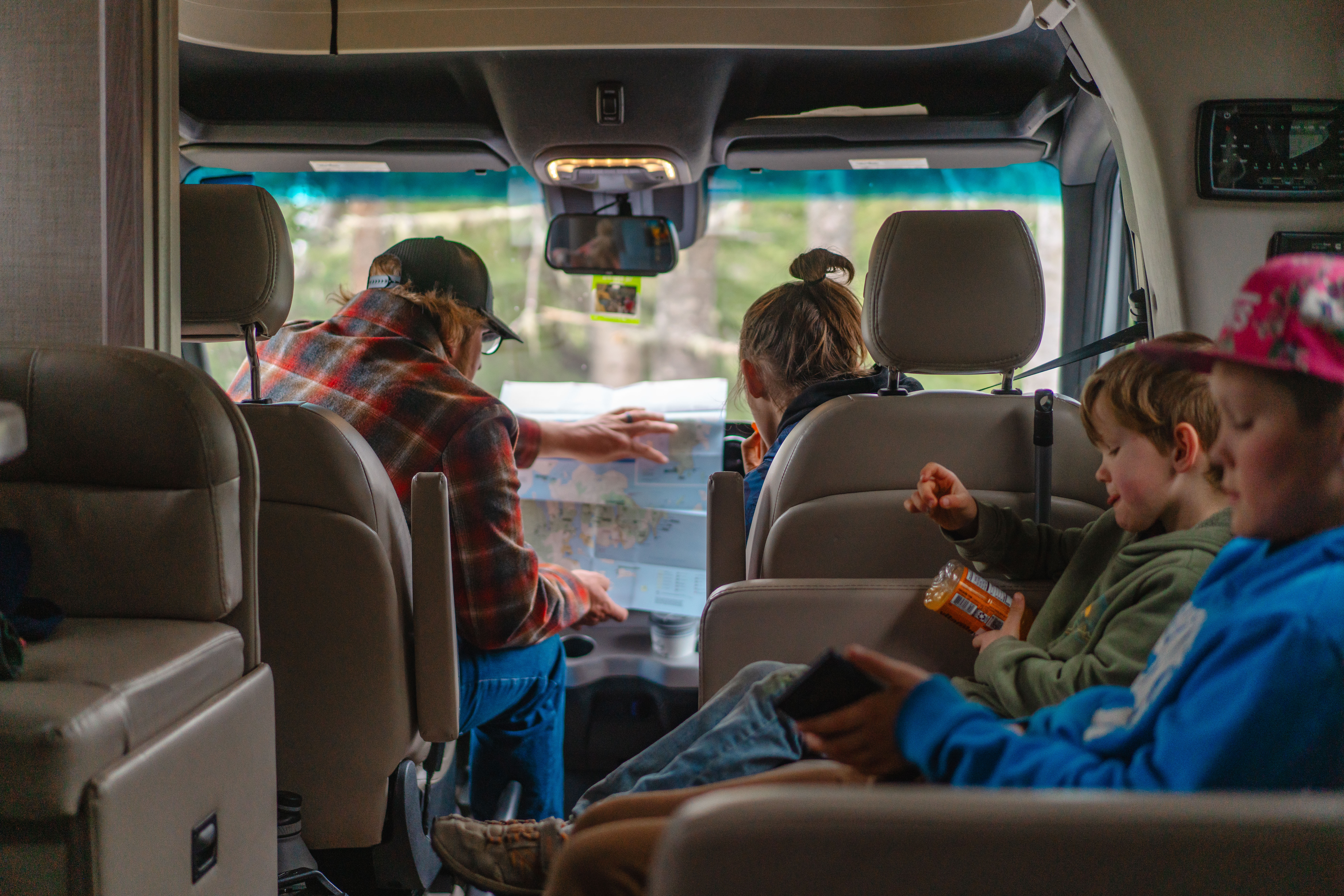 The Tilby family looks at a map while traveling in a rented motorized RV.