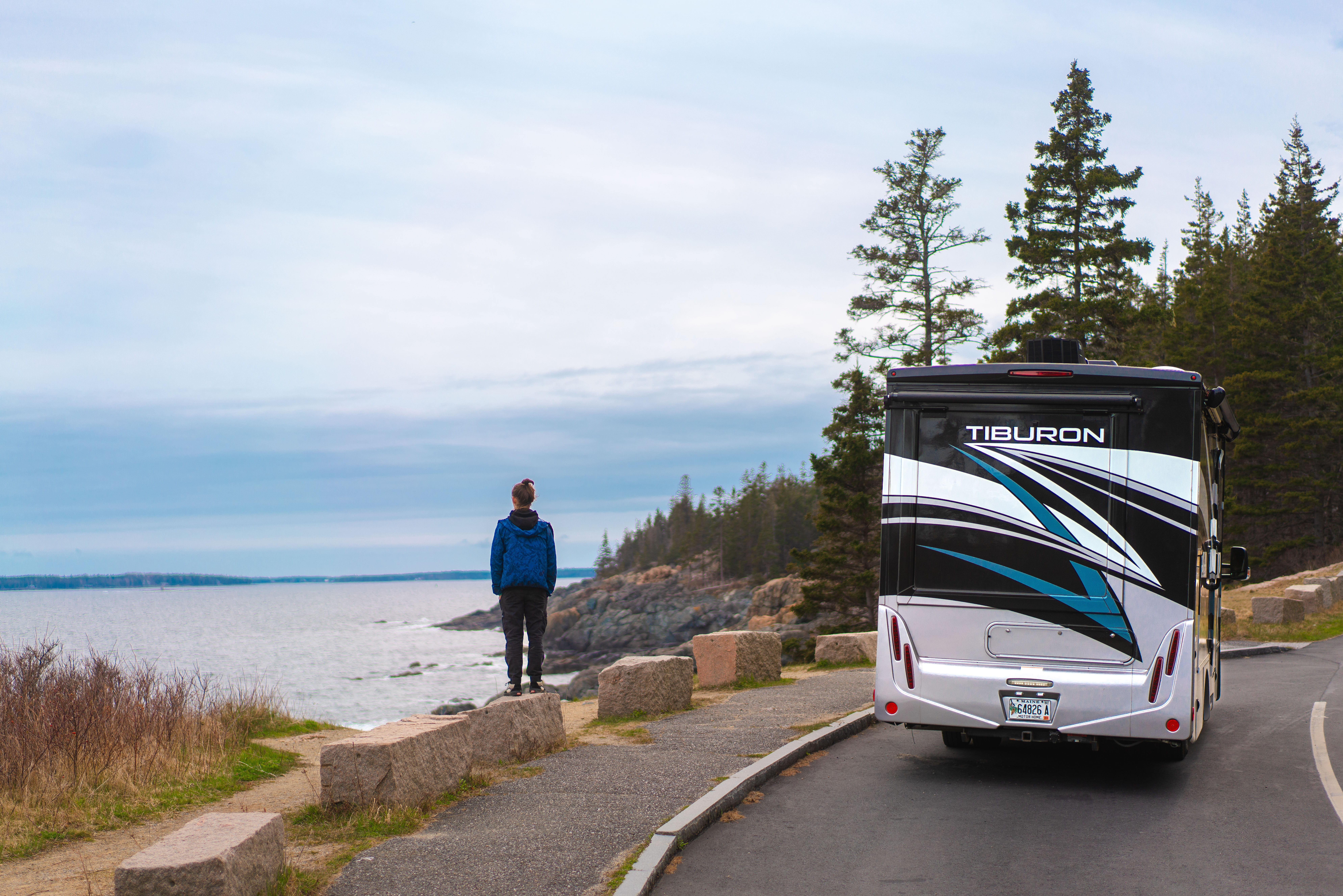 One of the Tilby kids stands at an overlook in Maine next to a rented motorized RV.