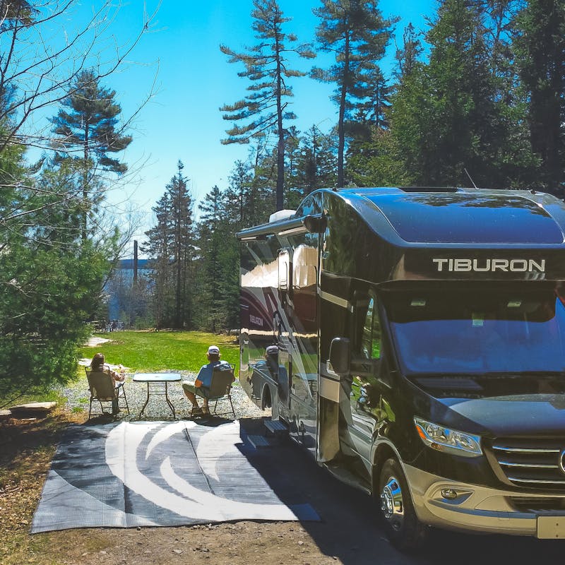 The Tilby family sits on the patio outside a motorized rented RV in Maine.
