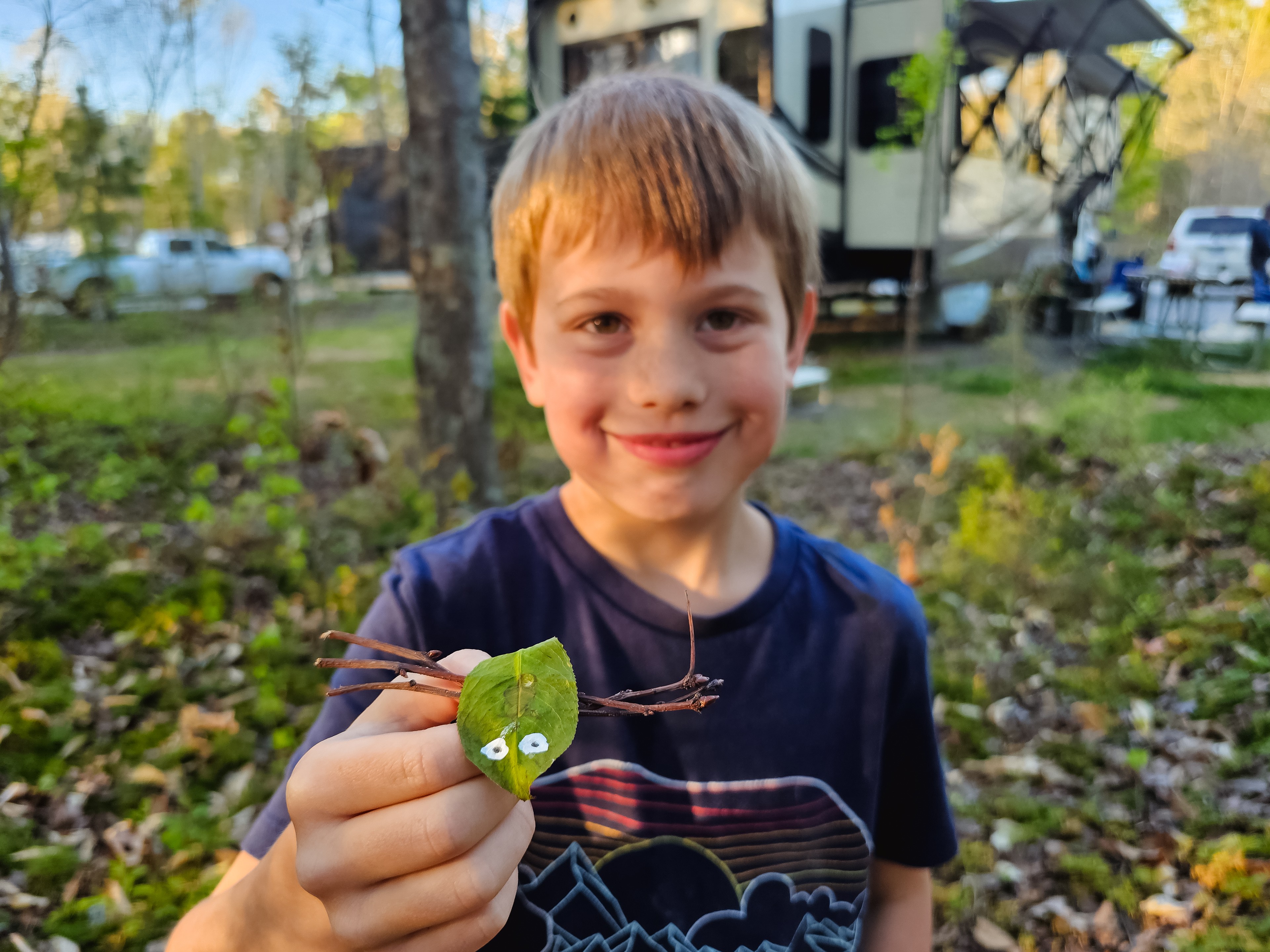One of the Barringer kids holds a leaf insect craft next to his KZ Durango Gold fifth wheel.