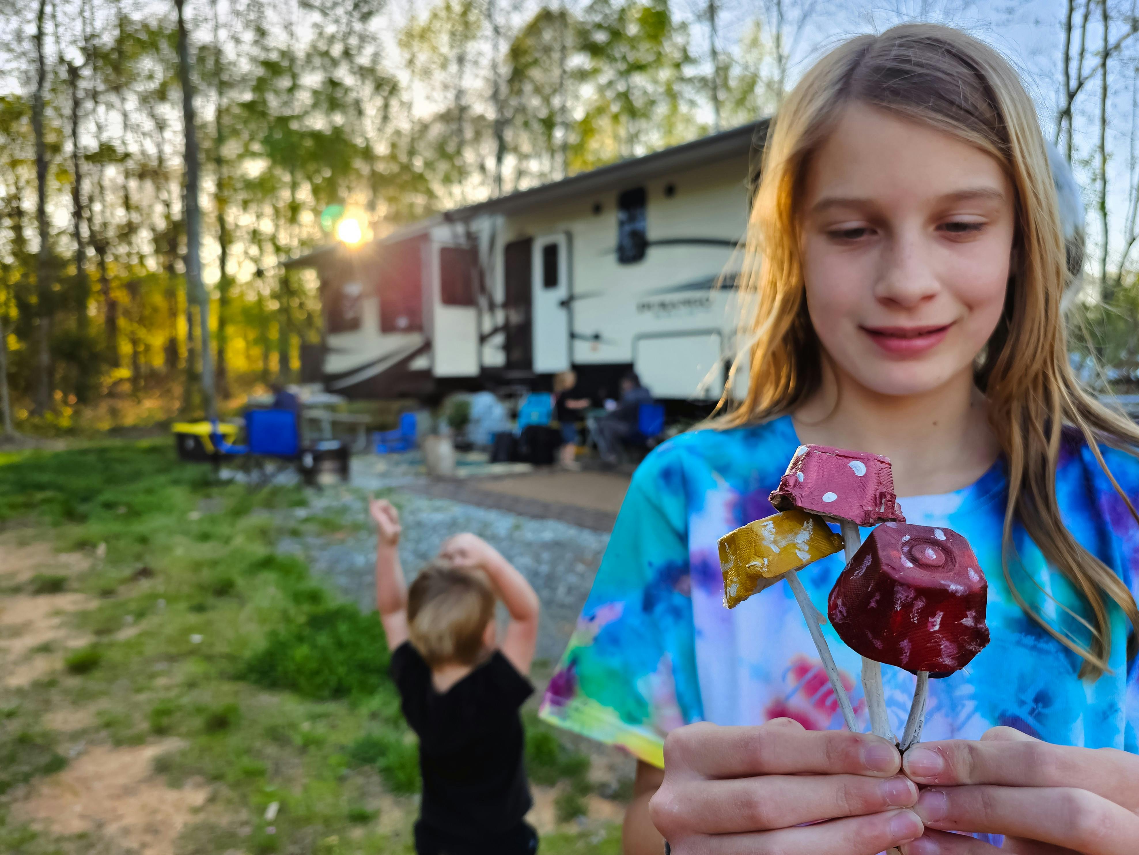 The Barringer kids showing off their mushroom crafts next to their KZ Durango Gold fifth wheel.