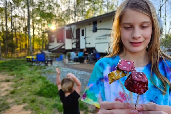 The Barringer kids showing off their mushroom crafts next to their KZ Durango Gold fifth wheel.