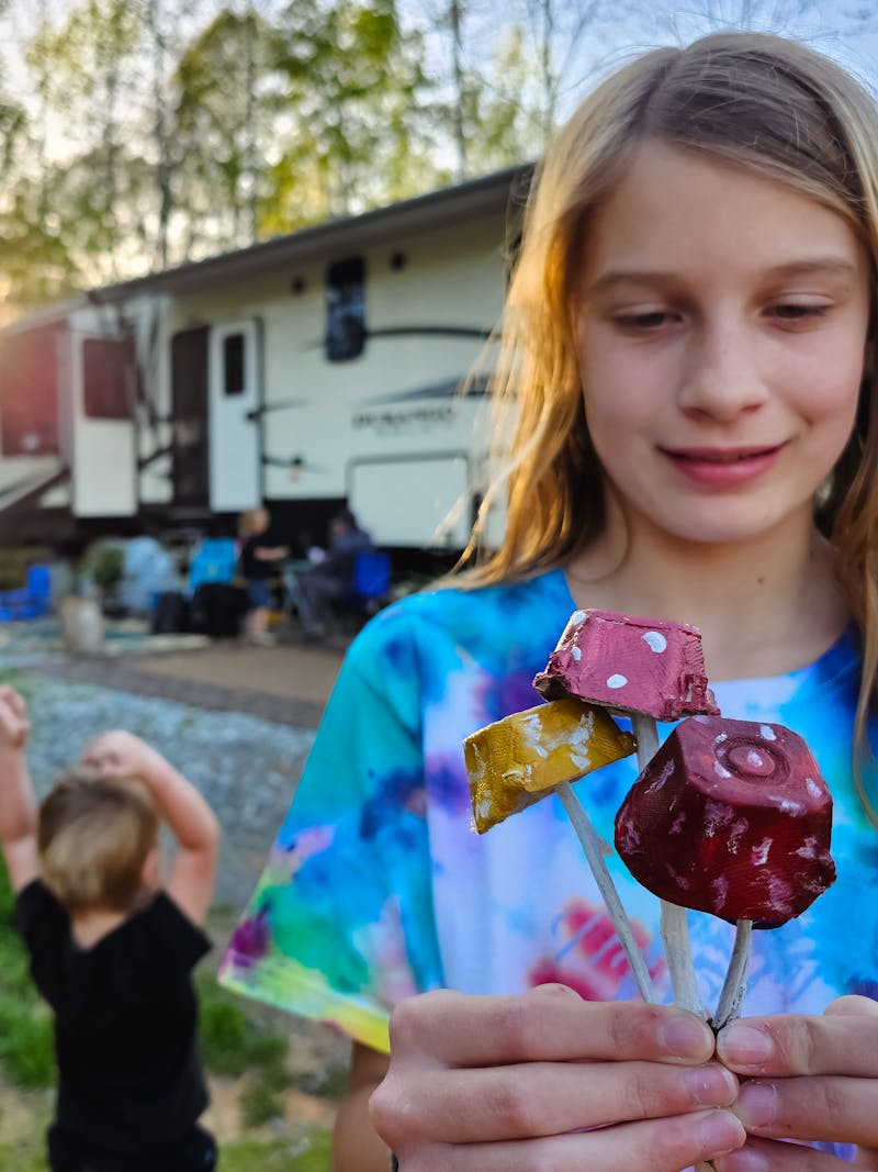 The Barringer kids showing off their mushroom crafts next to their KZ Durango Gold fifth wheel.