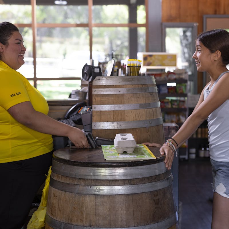 An employee cashes out one of the Peña kids at The General Store at the Temecula KOA Campground.