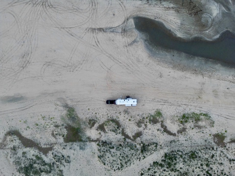 Cassie and Joshua Bailey's Highland Ridge Open Range fifth wheel parked in the sand.