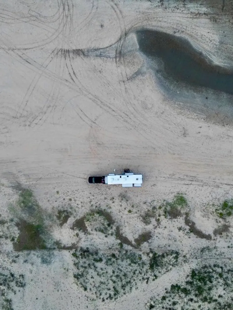 Cassie and Joshua Bailey's Highland Ridge Open Range fifth wheel parked in the sand.