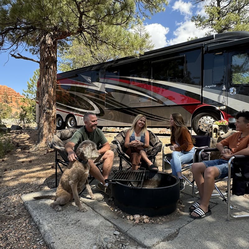 Carrie Cassity and her family sit around a fire ring next to their RV.