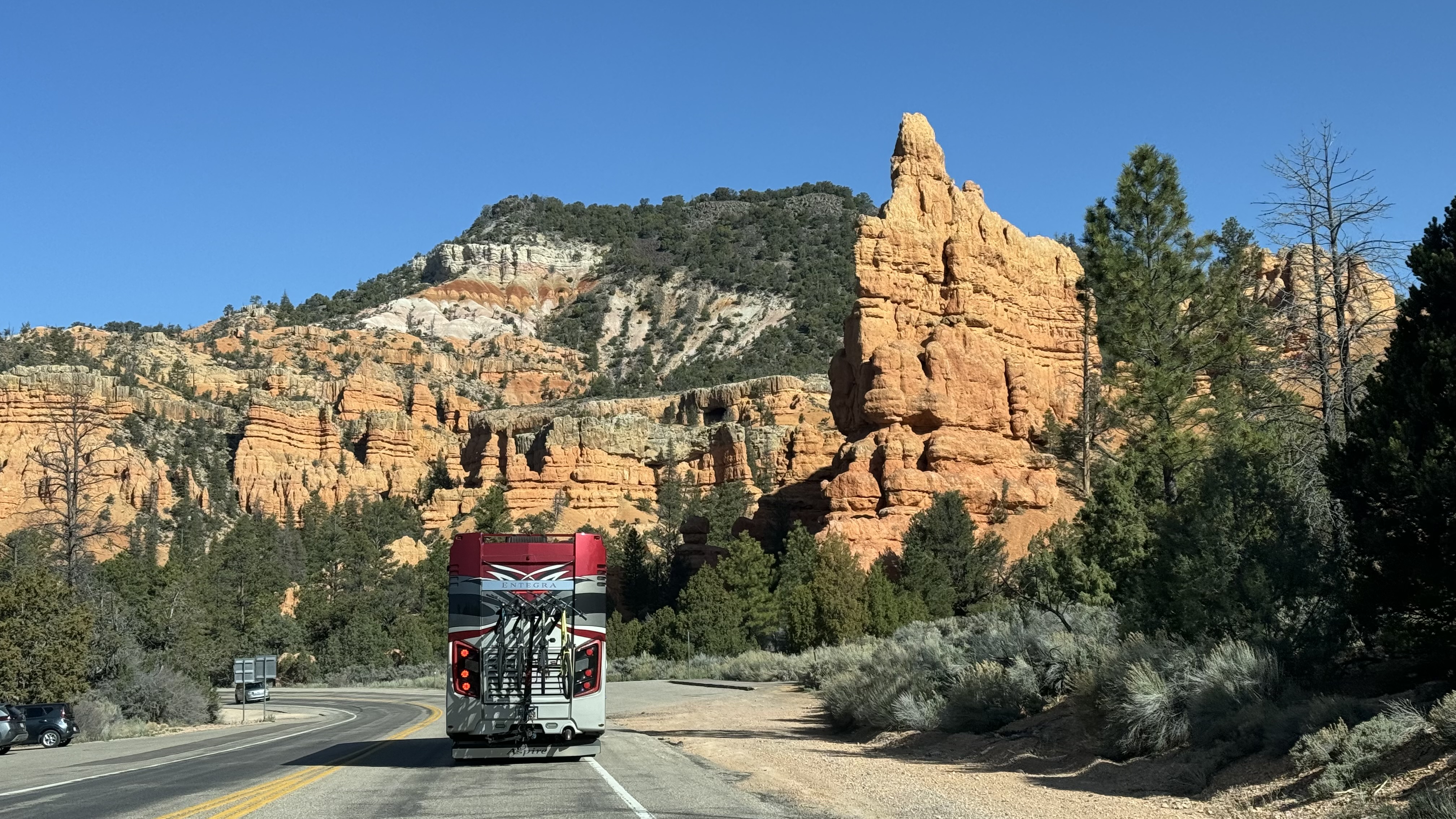 A Class A Entegra Vision motorhome driving down the road.