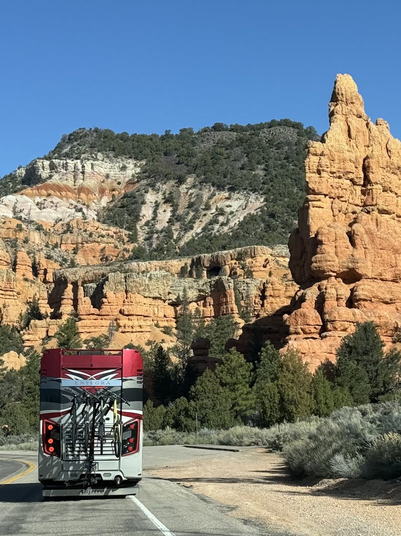 A Class A Entegra Vision motorhome driving down the road.