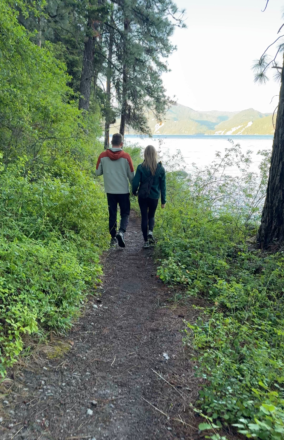Two people hiking along Lake Pend Oreille in Idaho Panhandle National Forest.