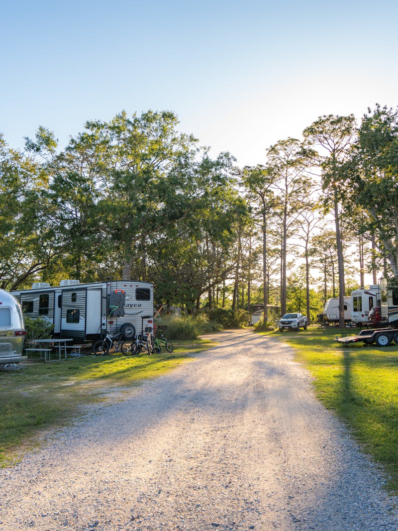 An Airstream and Jayco Jay Flight travel trailer parked at a campground.