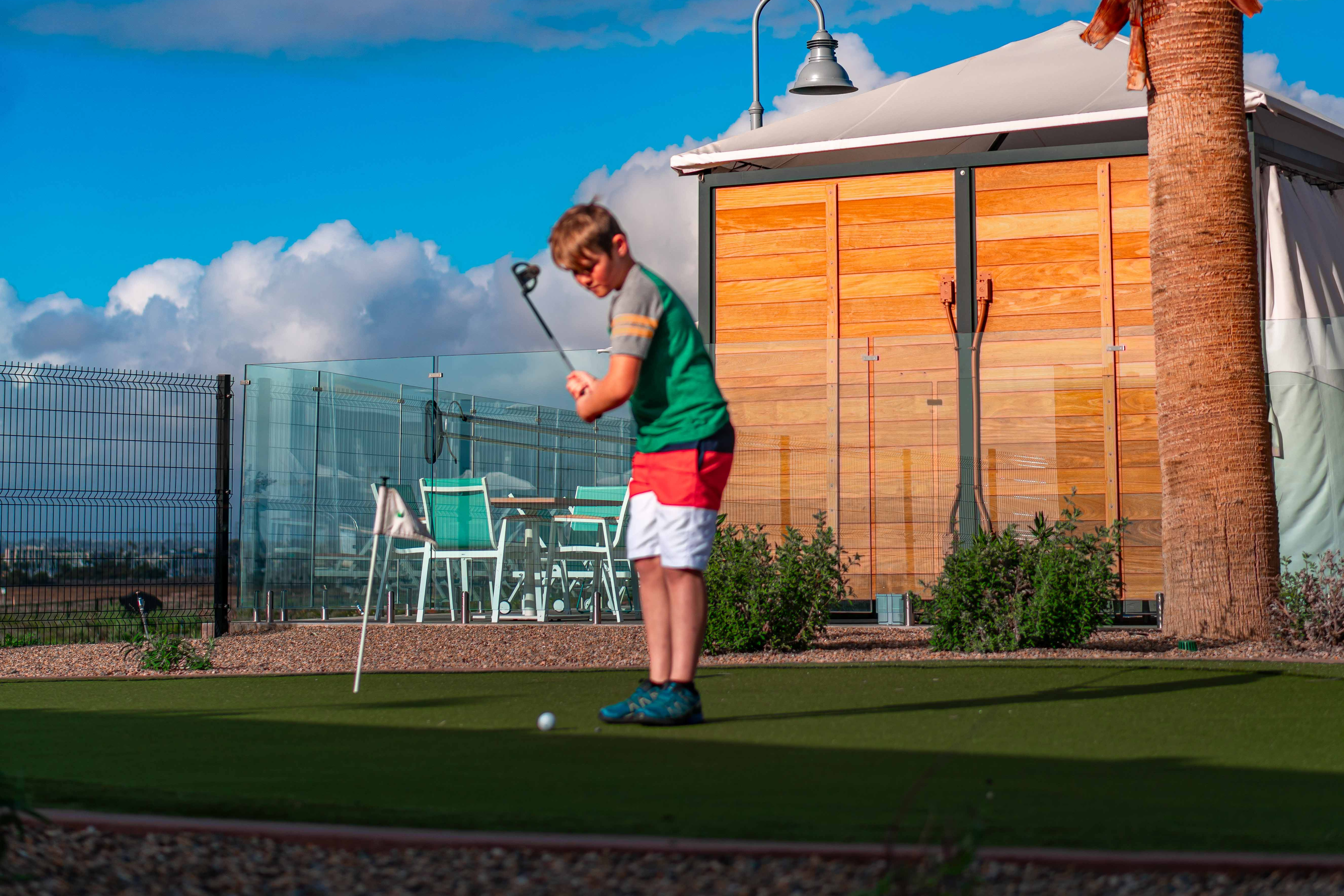 Renee Tilby's son plays putt putt golf at a campground.