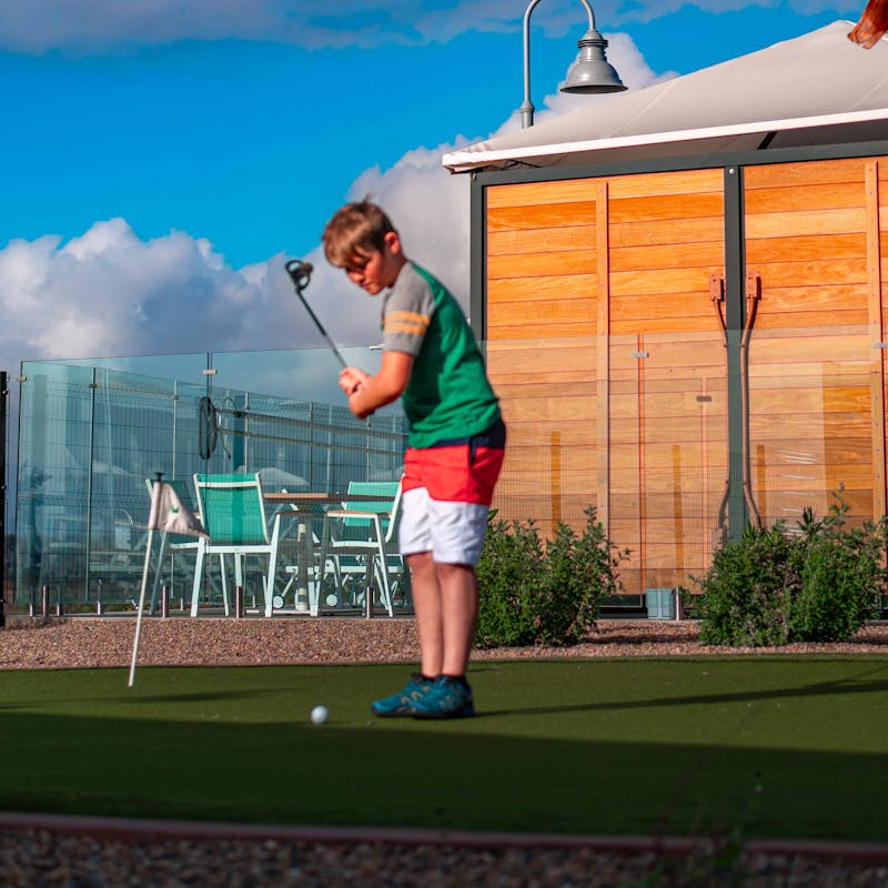 Renee Tilby's son plays putt putt golf at a campground.