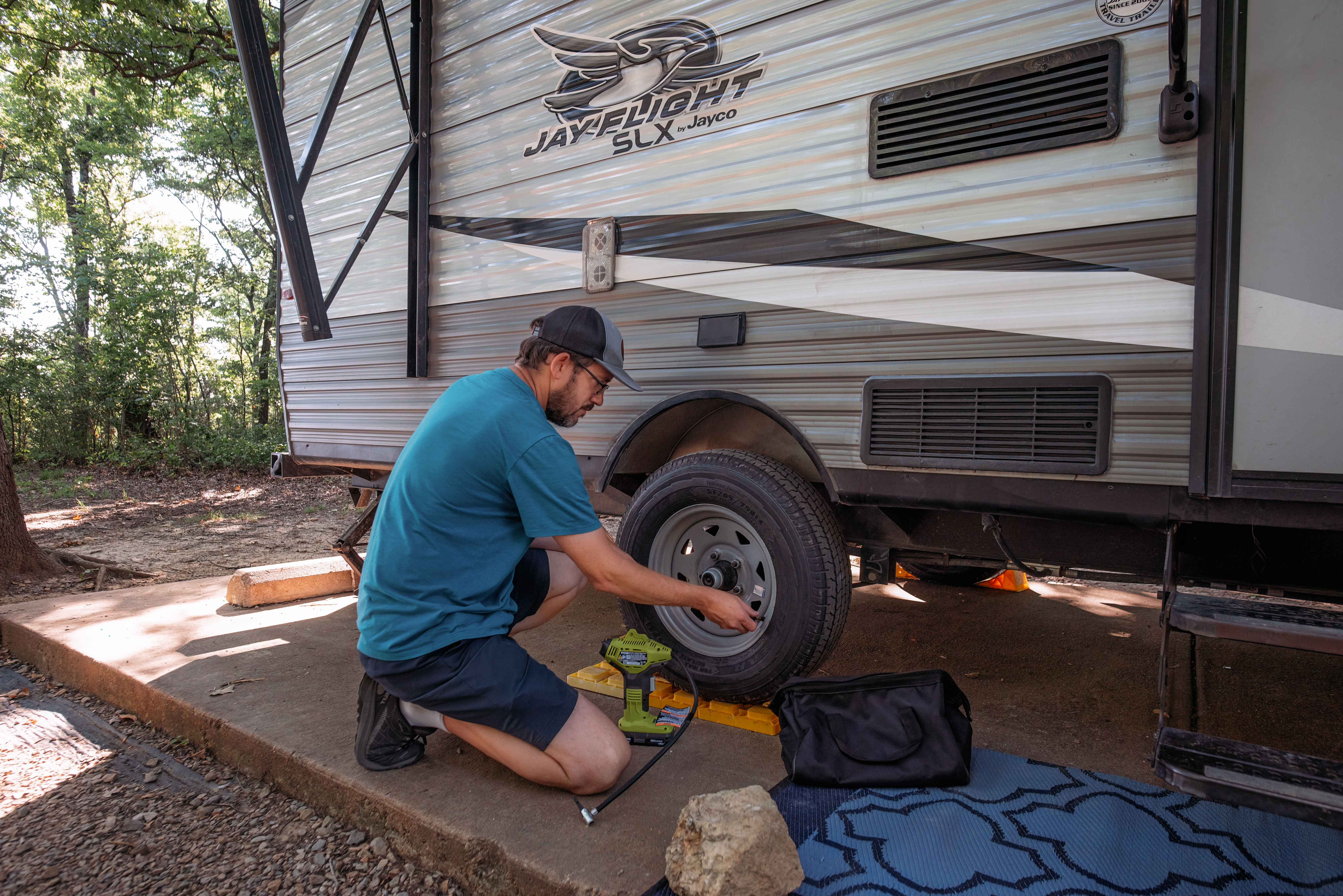 Jason Takacs checks the tire pressure on his Jayco Jay Flight travel trailer.