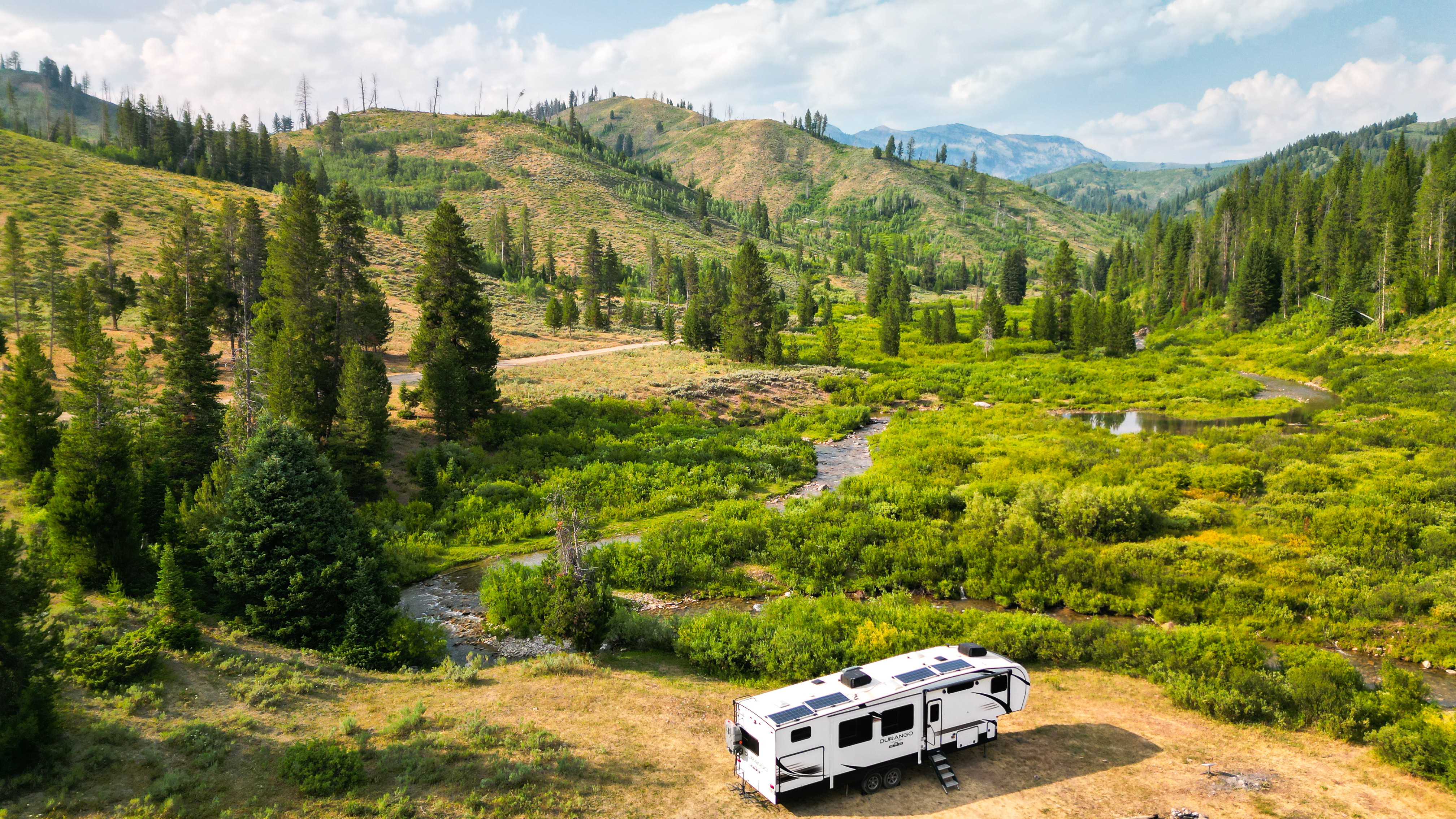 Sherise Gumbs' KZ Durango Gold parked in a lush valley in Granite Creek Dispersed Camping Area.