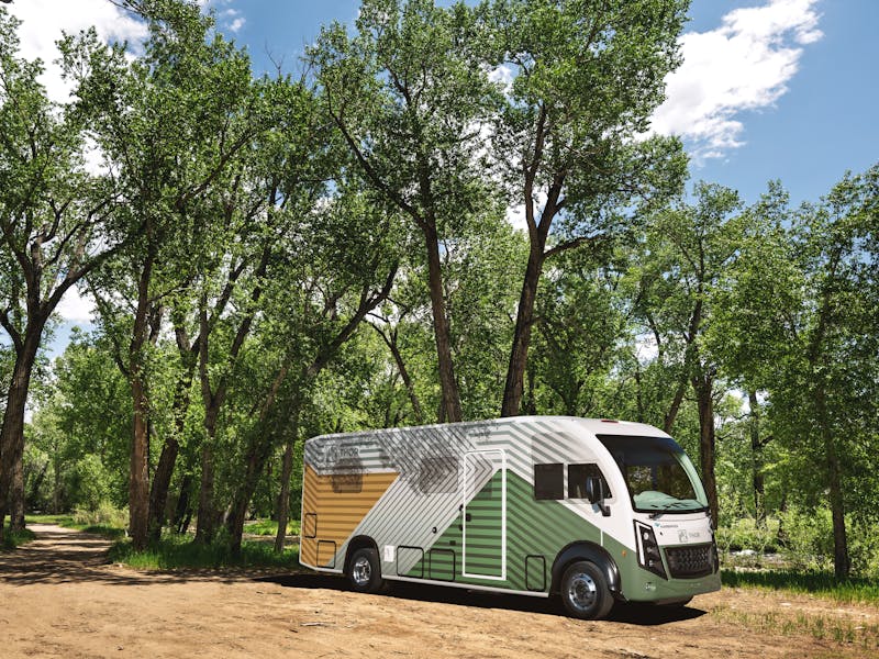 Harbinger Electric Chassis at a campsite near trees and a river