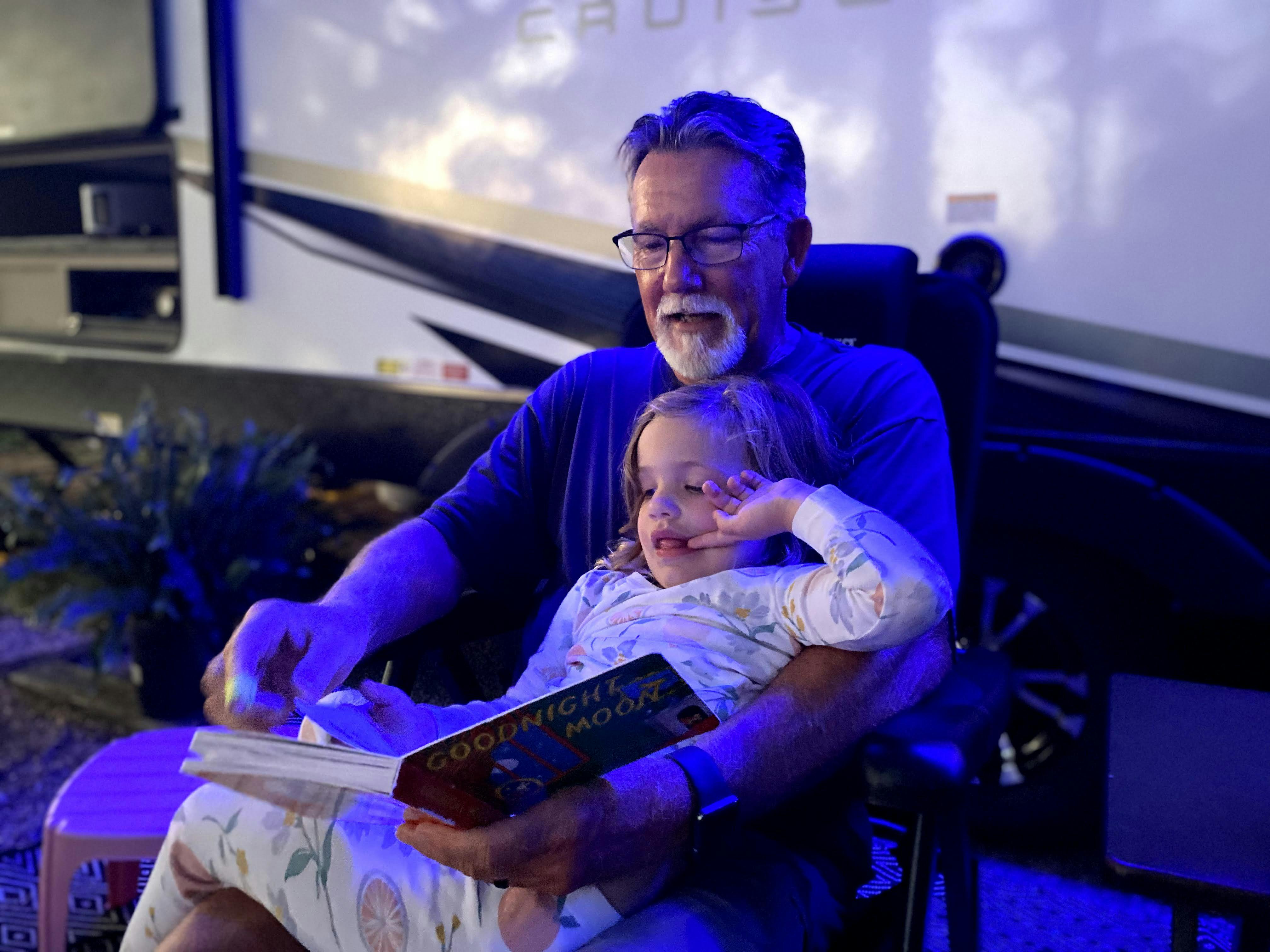 John King's dad reading a book to his granddaughter.