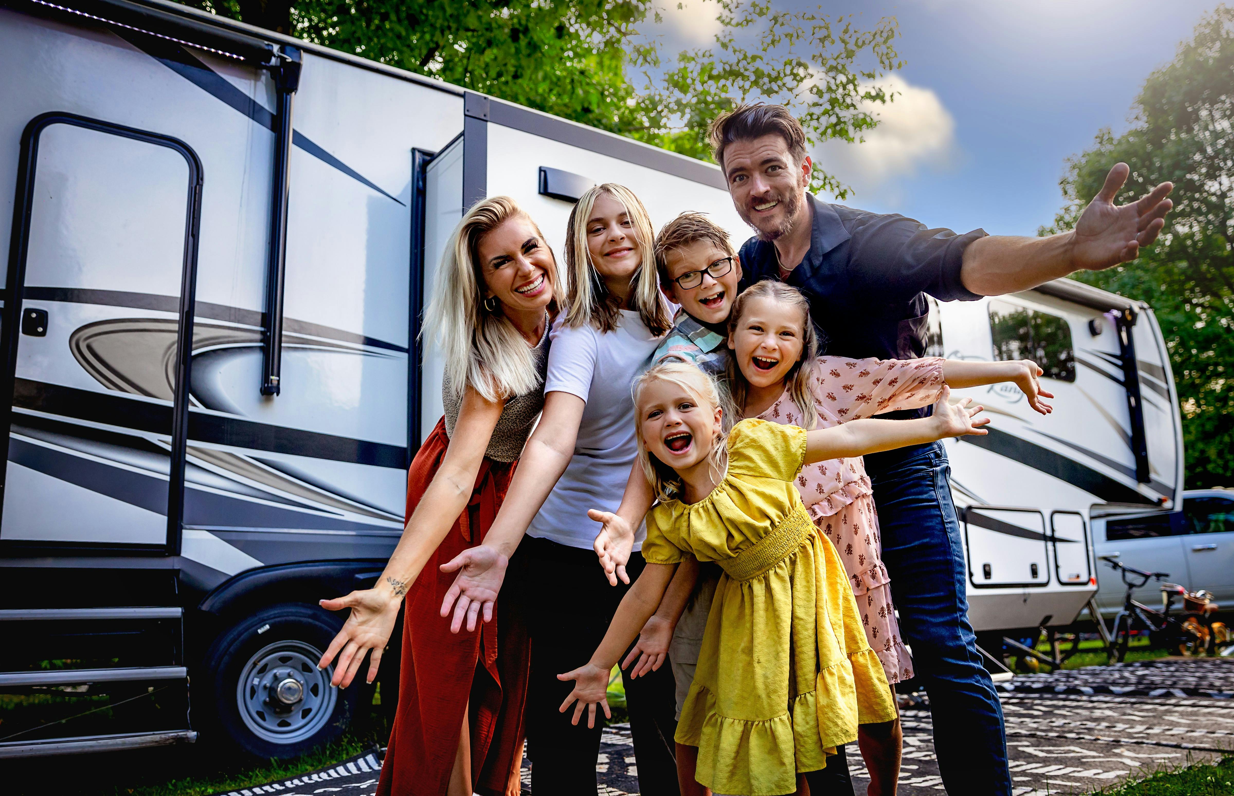 The Cassie and Josh Bailey family pose in front of their Highland Ridge Open Range fifth wheel.