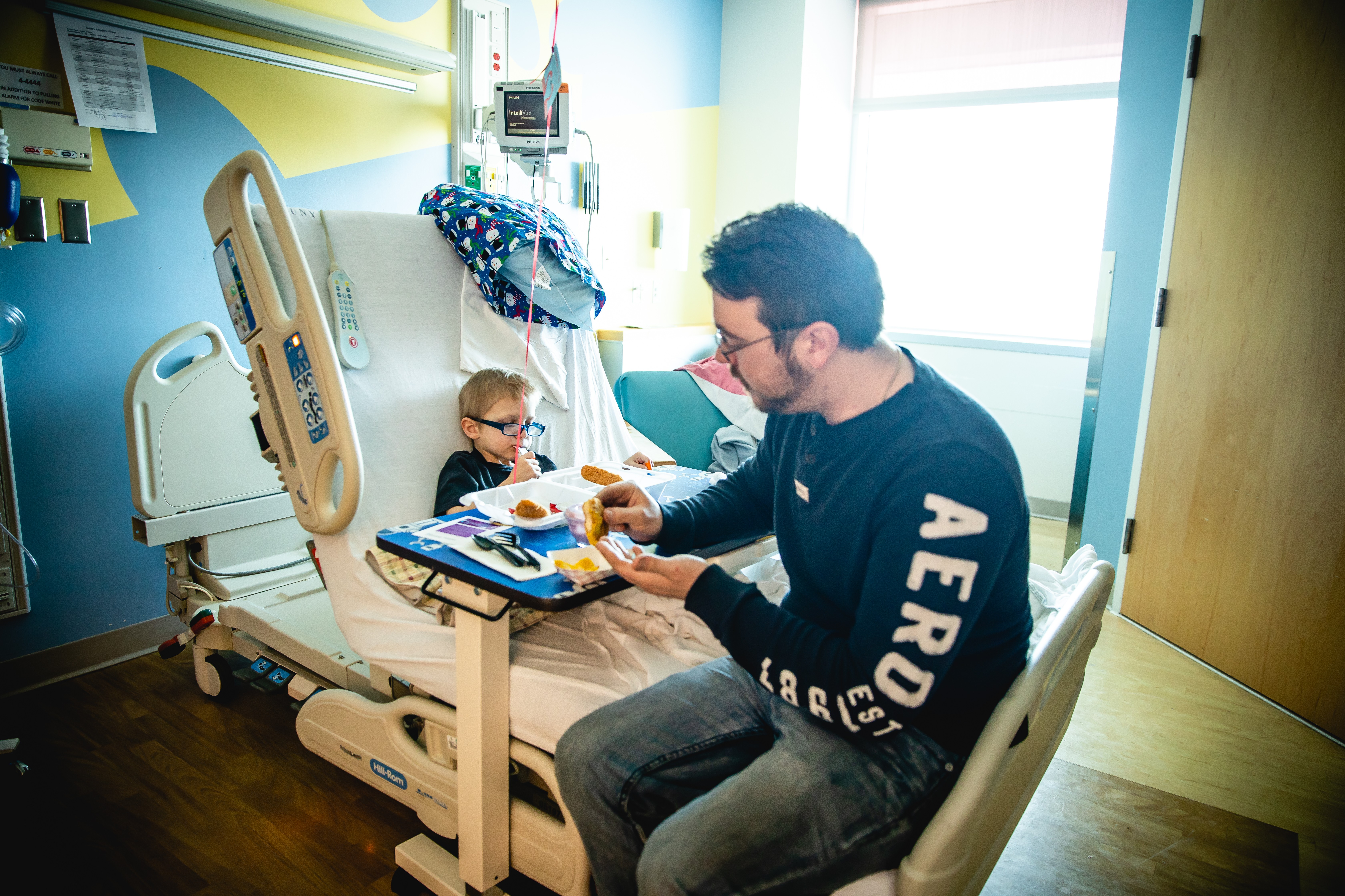 Joshua Bailey sits with his son in the hospital.
