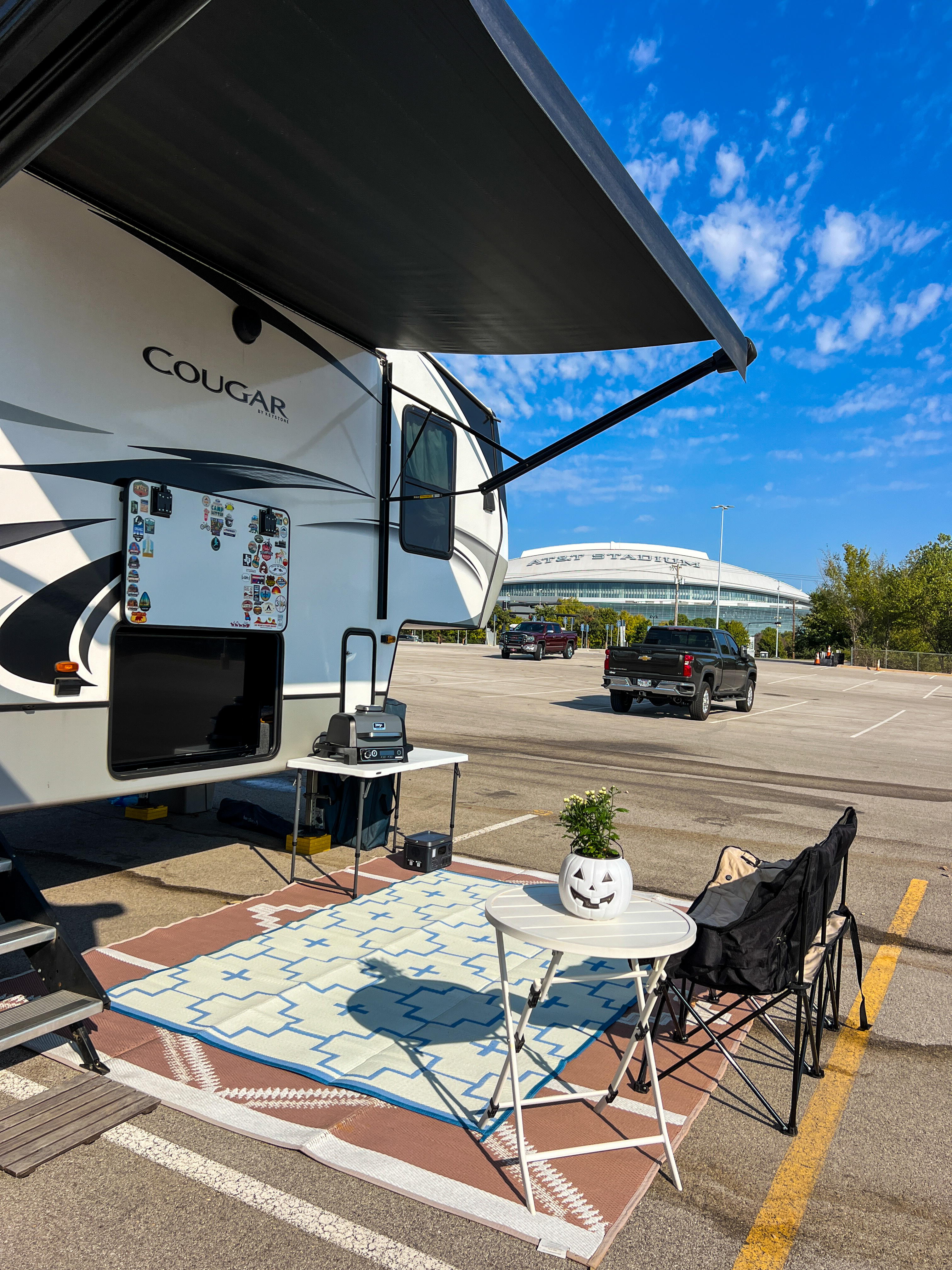 Donny and Tammy Benedict's tailgating set-up next to their Keystone Cougar fifth wheel at a stadium.