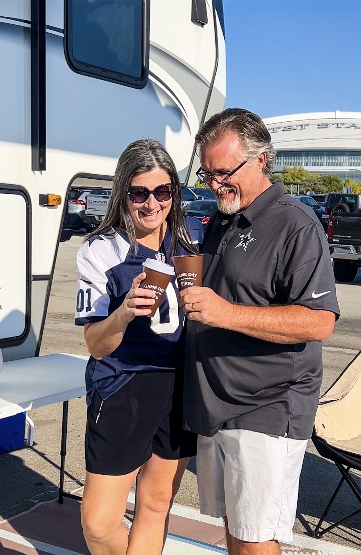 Donny and Tammy Benedict toasting next to their Keystone Cougar fifth wheel.