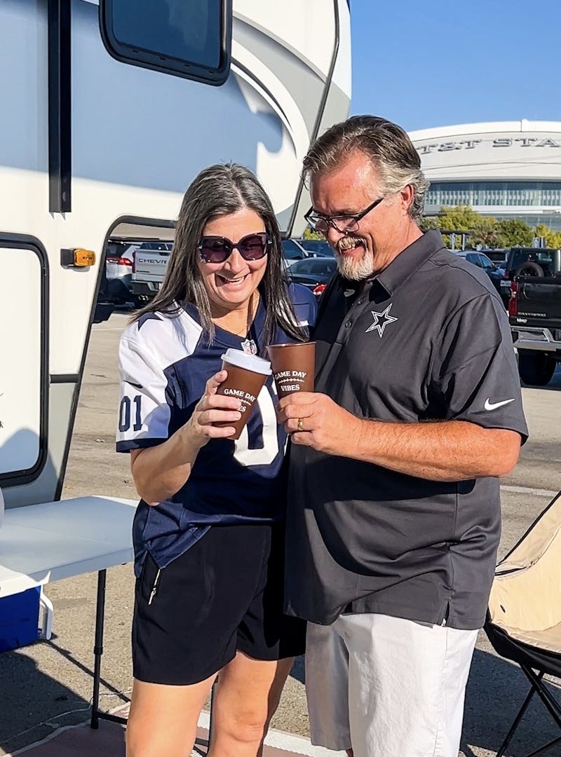 Donny and Tammy Benedict toasting next to their Keystone Cougar fifth wheel.
