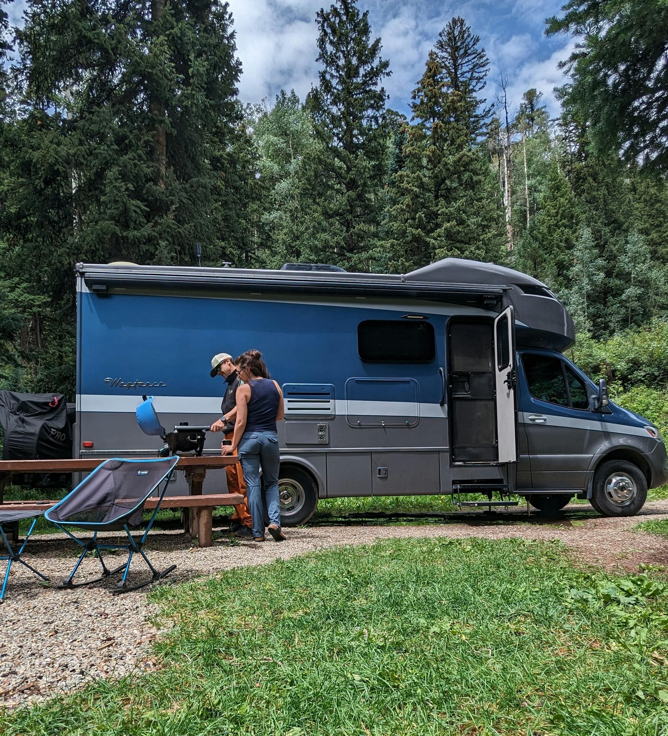 Sarah and Dustin Bauer grill at their campsite with their Tiffin Wayfarer.