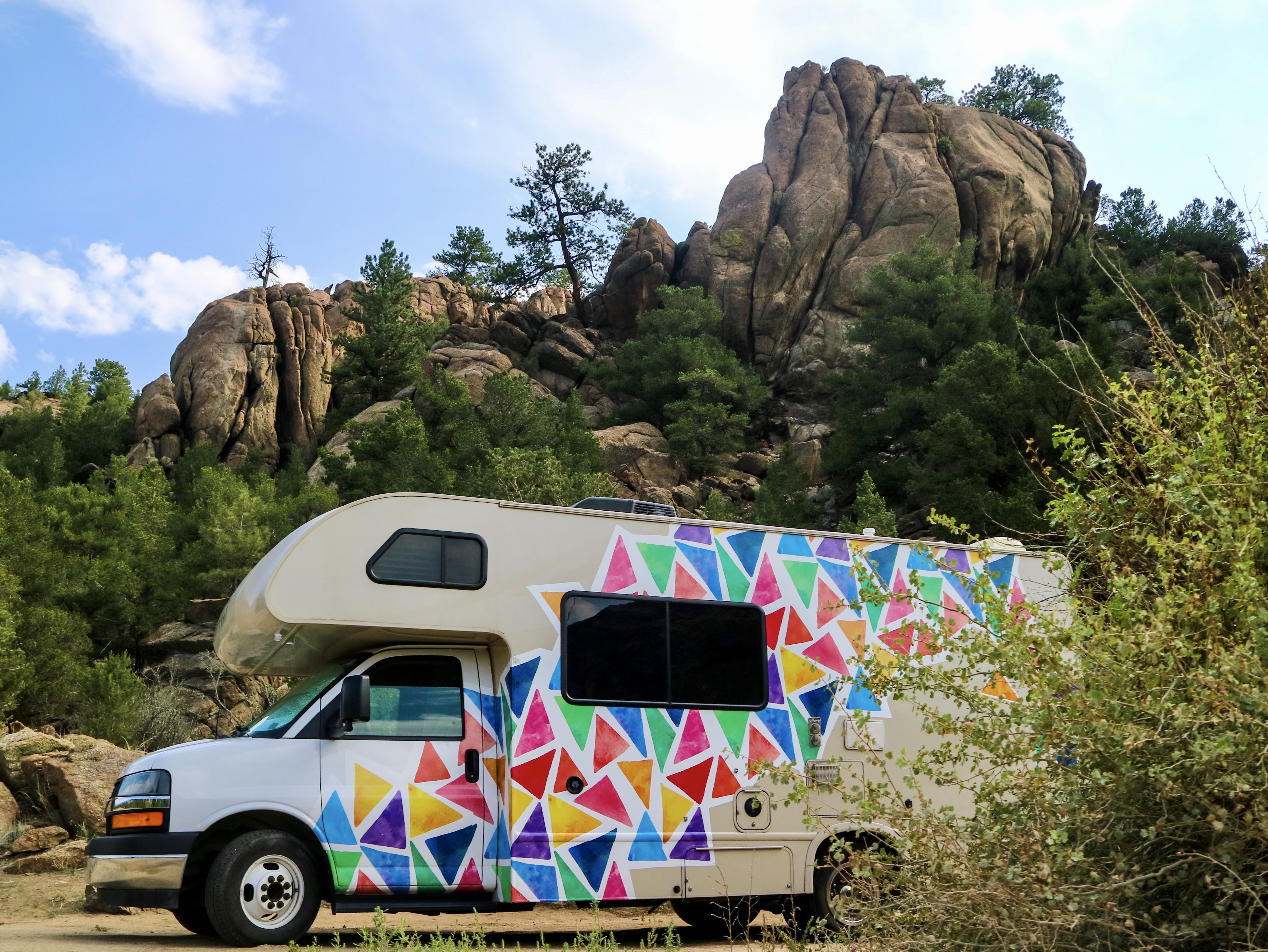 Jason and Dawn's Class C RV parked near large rocks as they boondock.