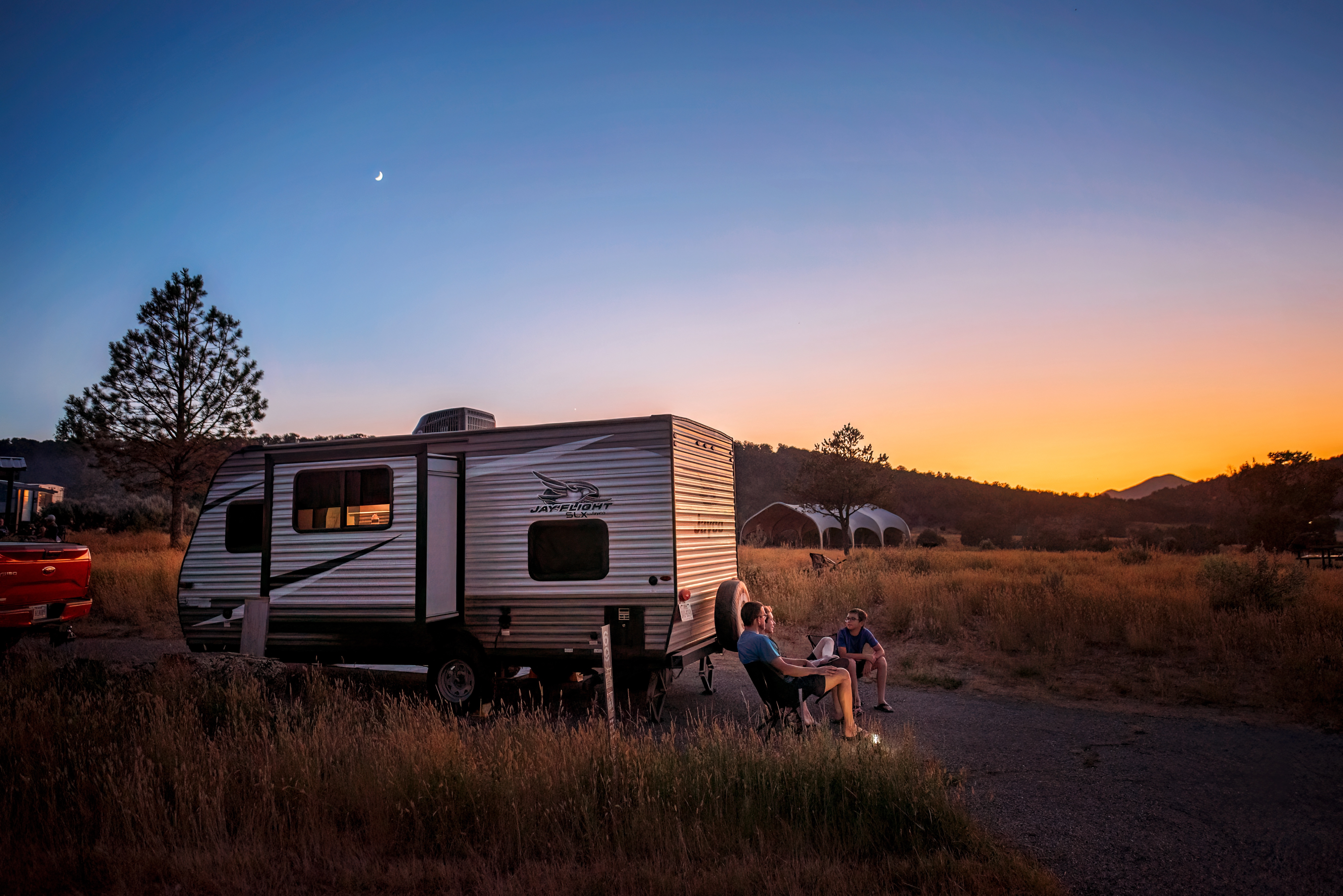 The Jason and Alison Takacs family watching a sunset outside their Jayco Jay Flight